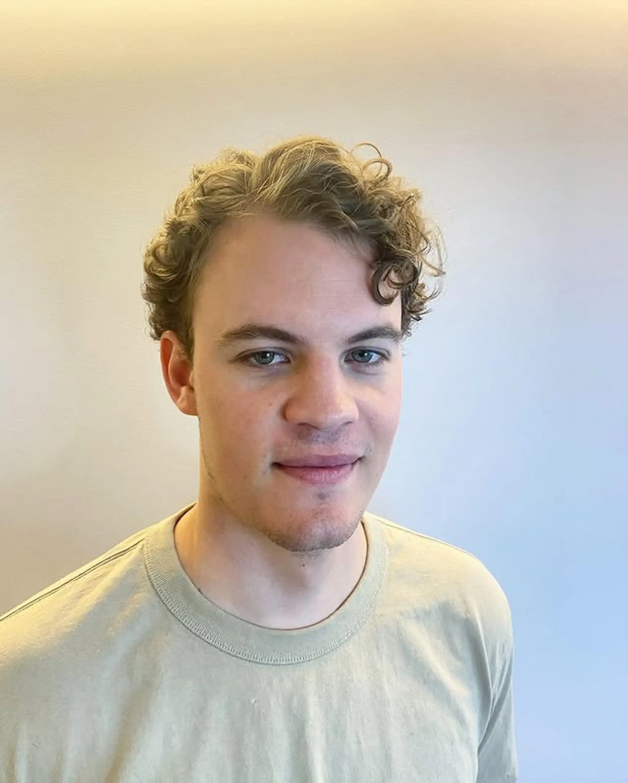 A short, stylish haircut designed to enhance natural curls, creating a modern and textured look.