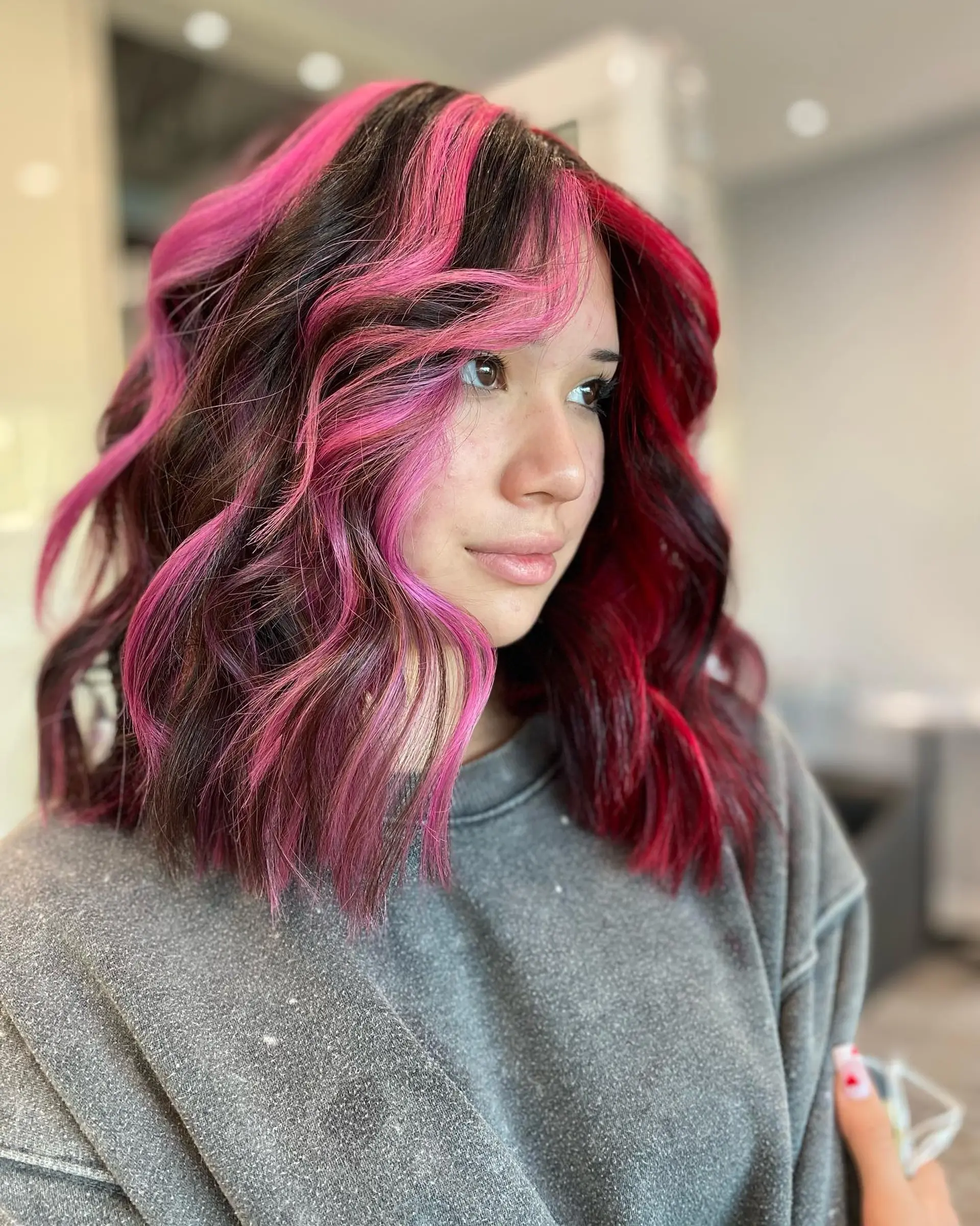 Shoulder-length wavy hair with a striking split dye, featuring a bold pink and red color combination. 1