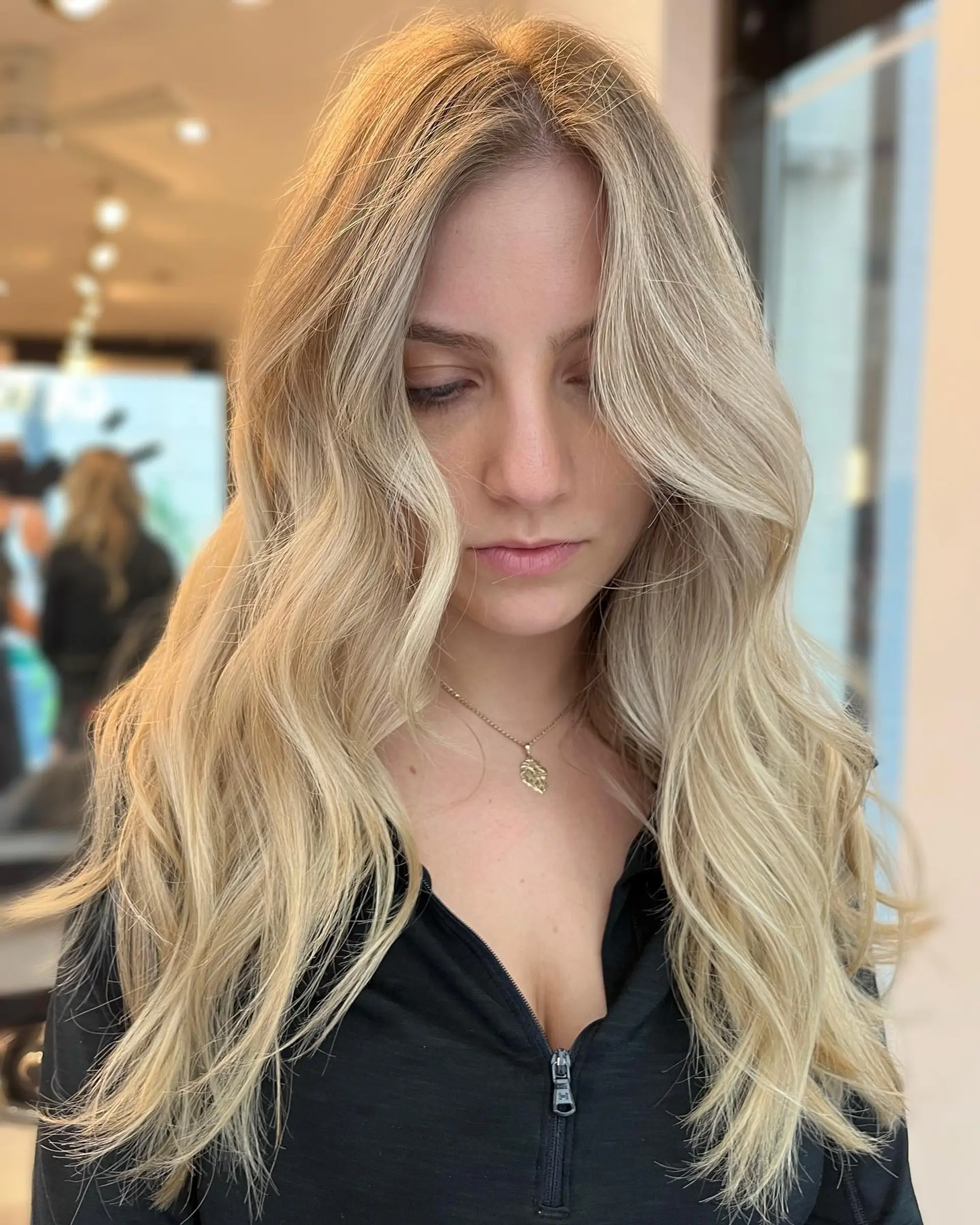 Long, wavy blonde hair styled with a balayage technique to create beach waves. 1
