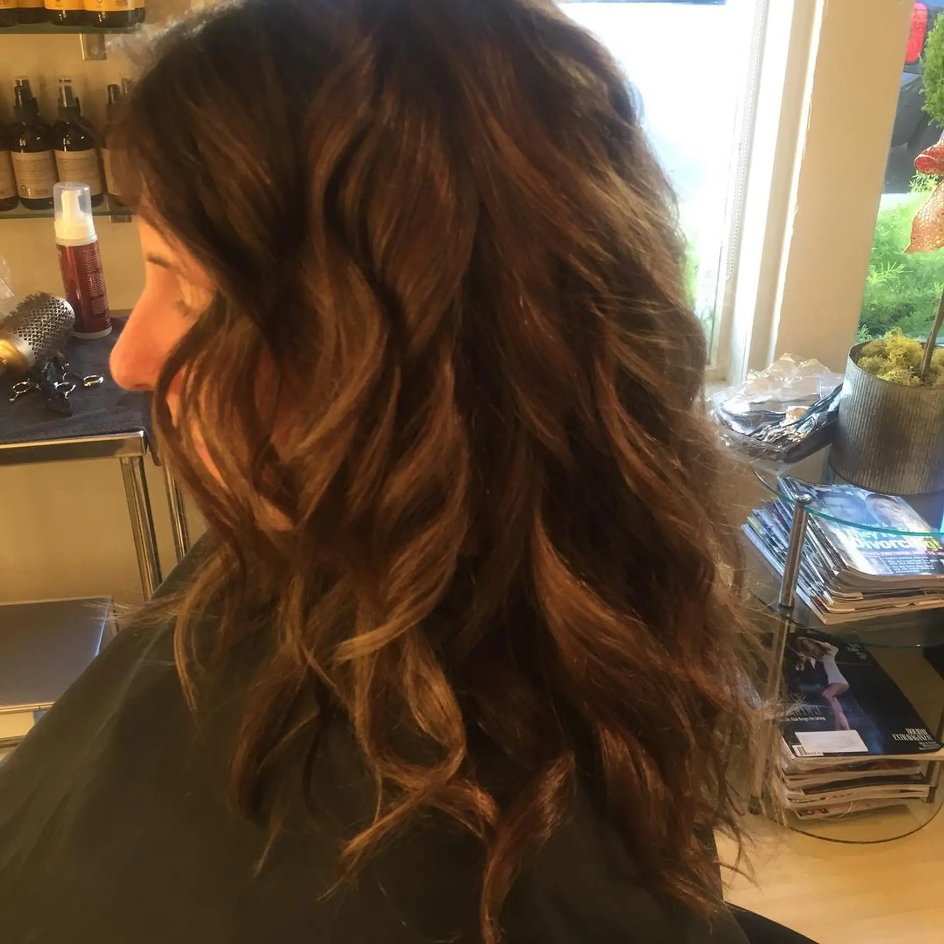 Rich, warm chocolate brown hair styled into polished, loose curls. 1