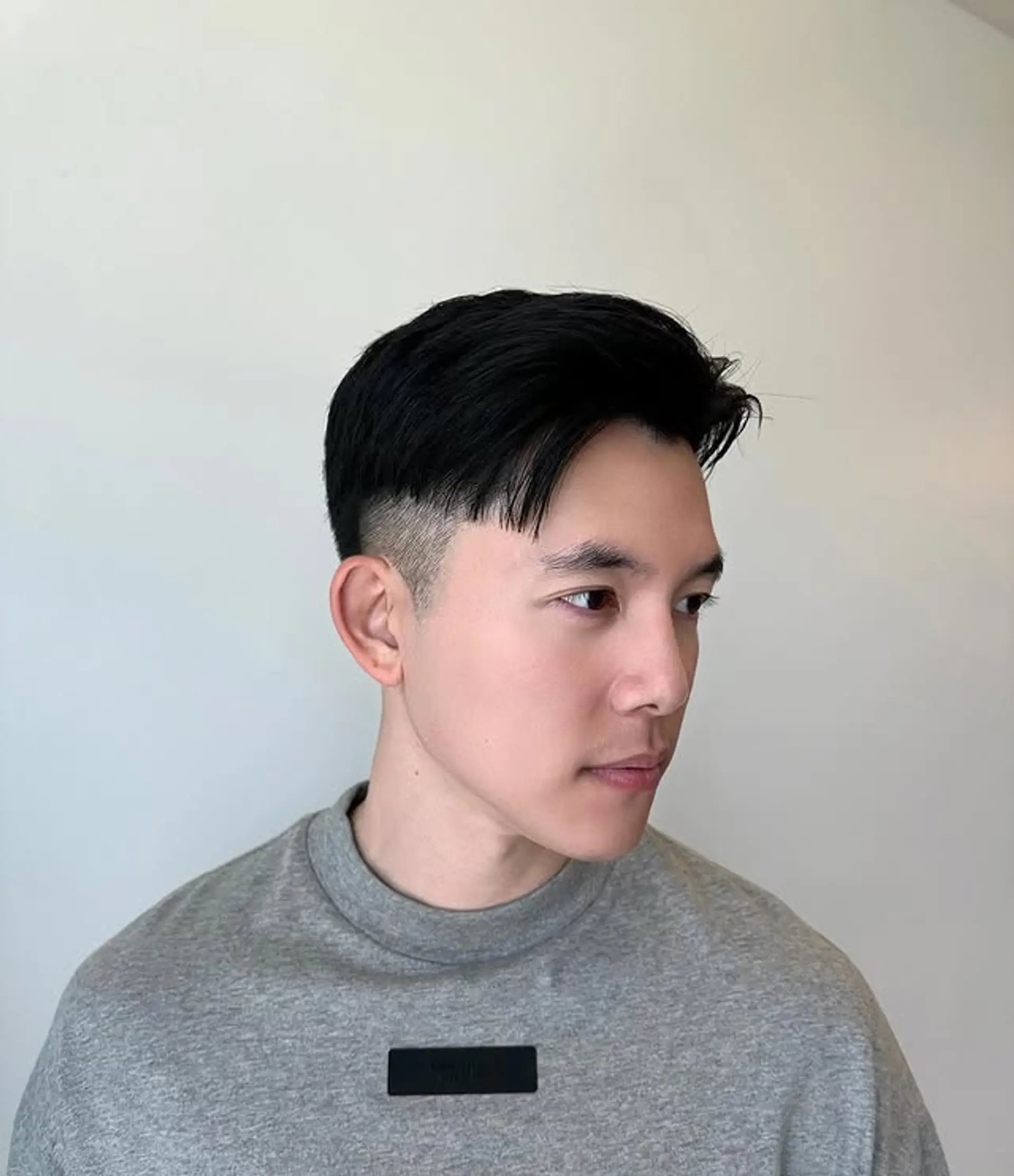 A modern short hairstyle featuring a fade with a comma-shaped fringe. 1