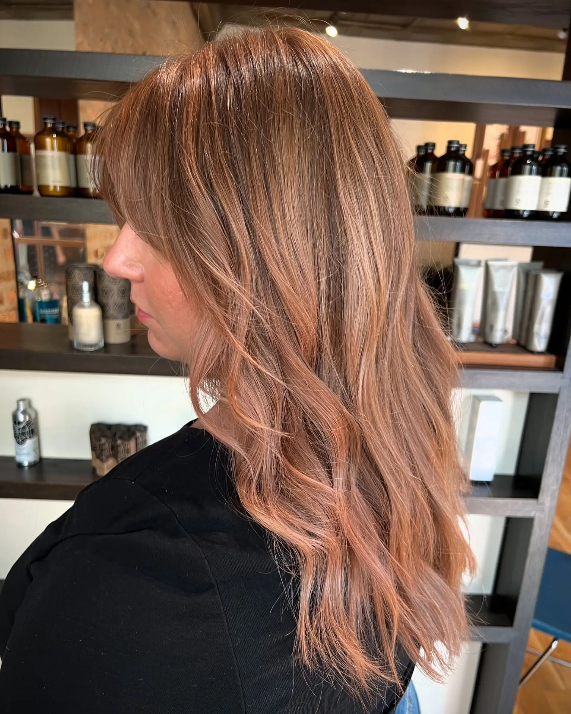 Long wavy hair with curtain bangs and a rose gold balayage. 1
