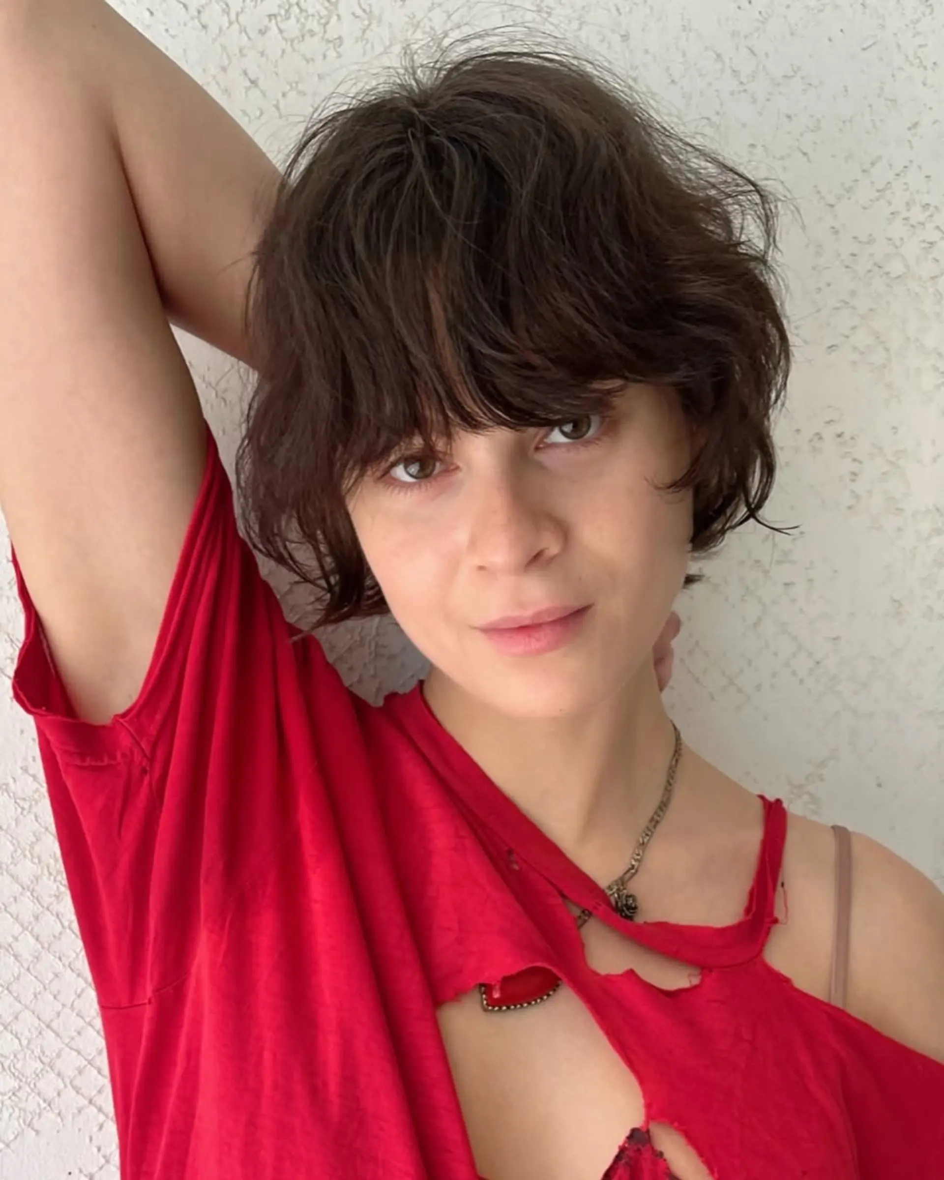 Short, wavy brown hairstyle with layered and textured locks, accompanied by a relaxed fringe for an effortless, bohemian appearance. 3