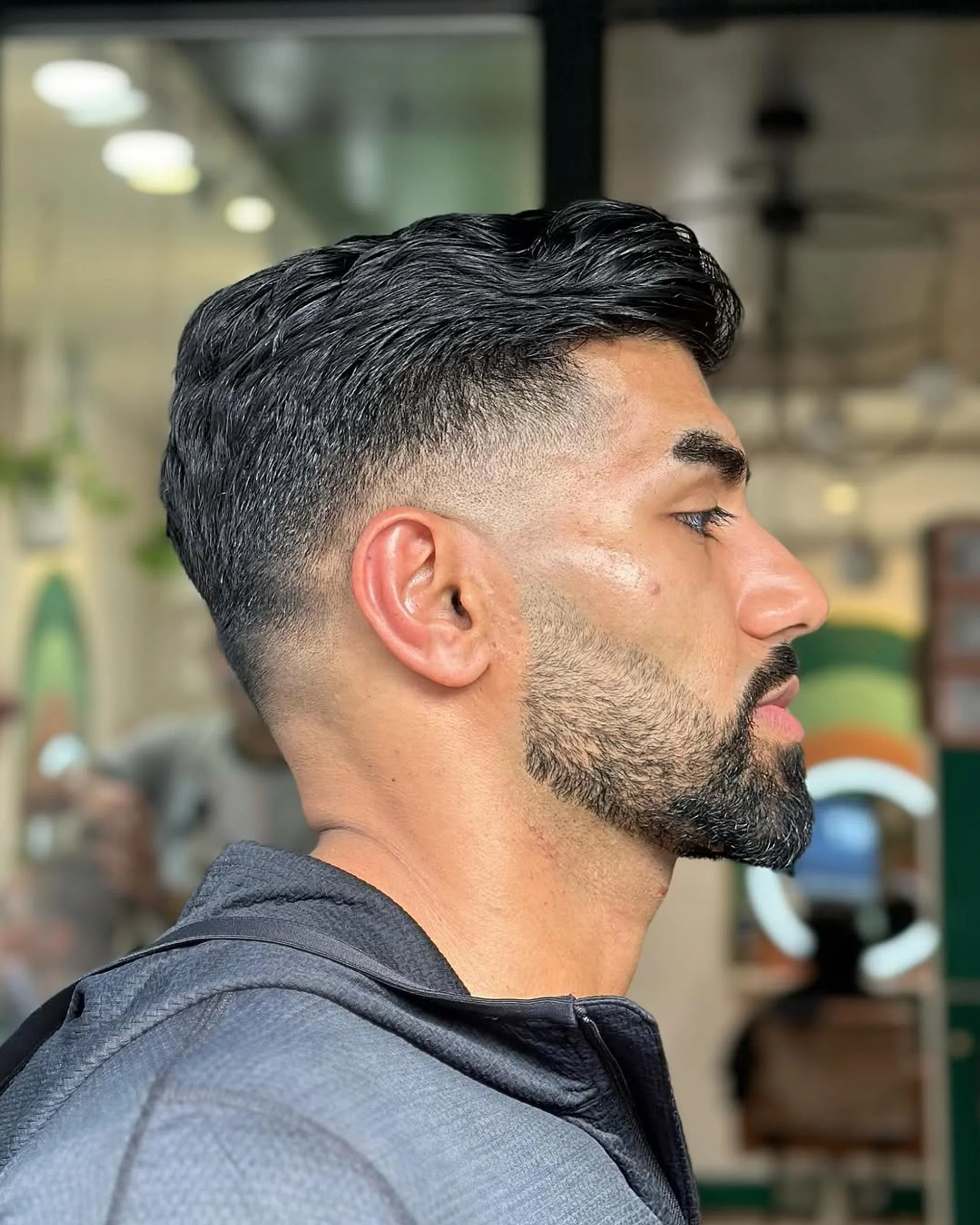 Man with a stylish textured pompadour haircut and a neatly trimmed beard - Preview 2