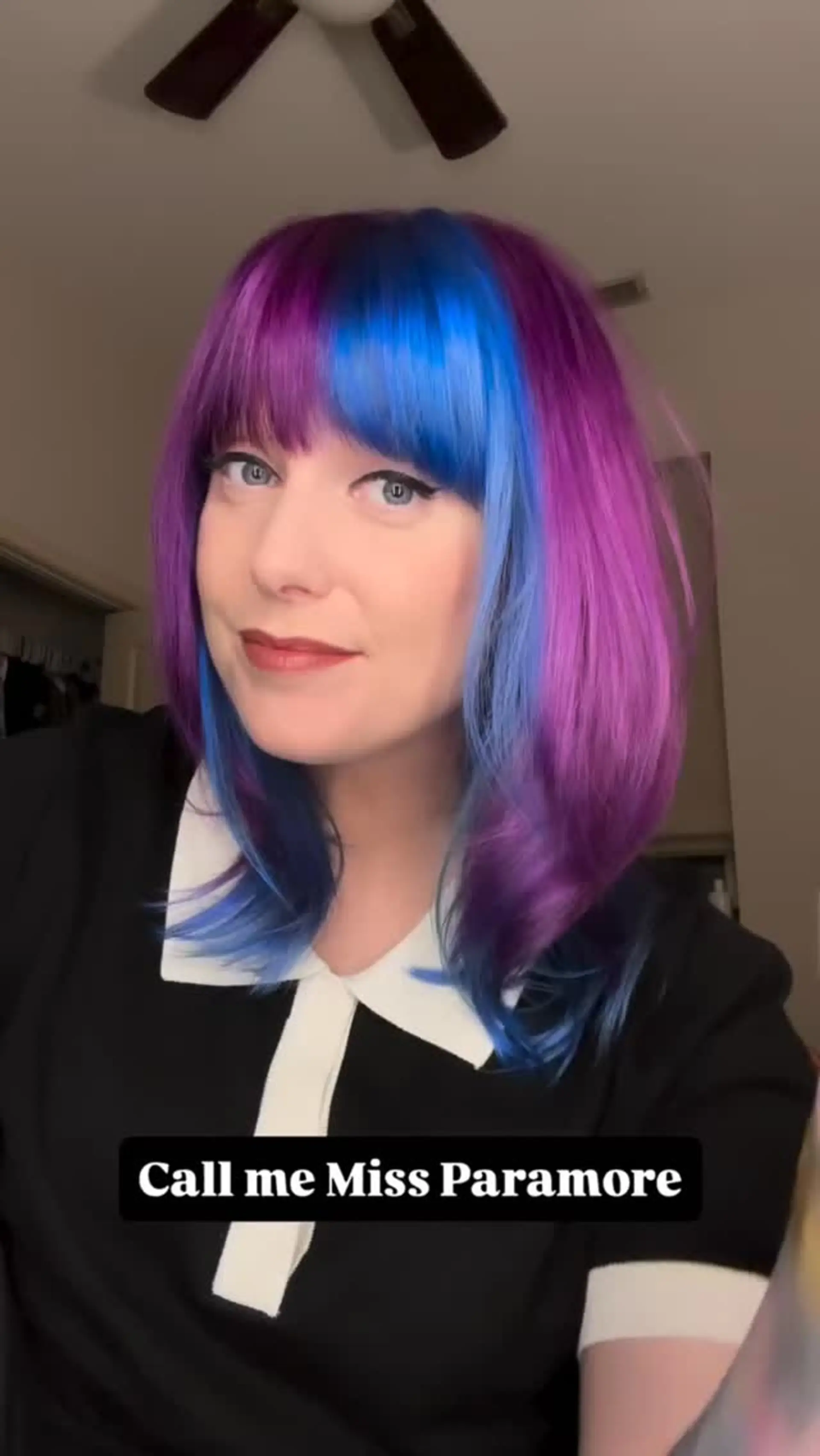 A vivid color-blocked shoulder-length lob styled with straight bangs, showcasing deep purple tones alongside a bold electric blue front section. 1