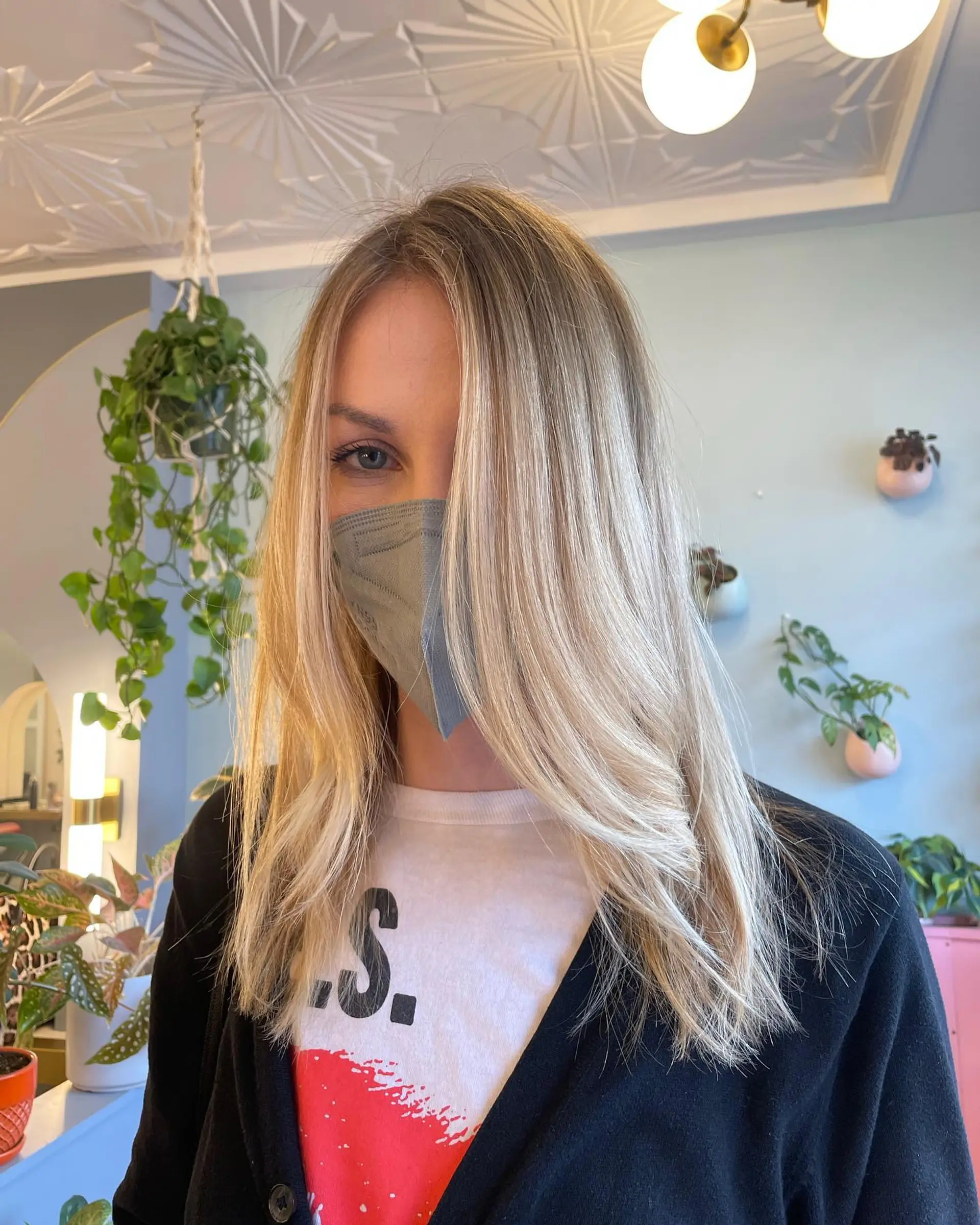 The hairstyle features long layers and is styled with a subtle wave, creating a soft and feminine look. The icy blonde balayage adds depth and dimension to the hair, making it a trendy and eye-catching style. 1