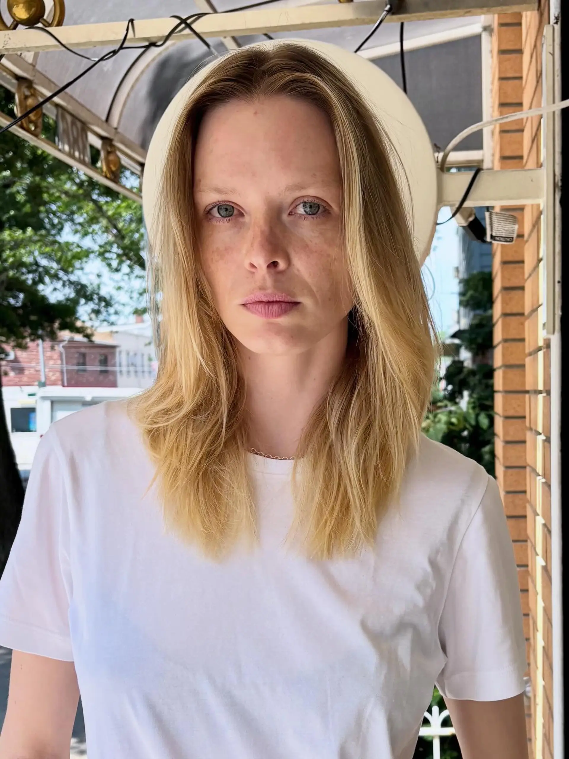 Medium-to-long straight blonde hair parted in the center with face-framing subtle layers and textured ends. 1