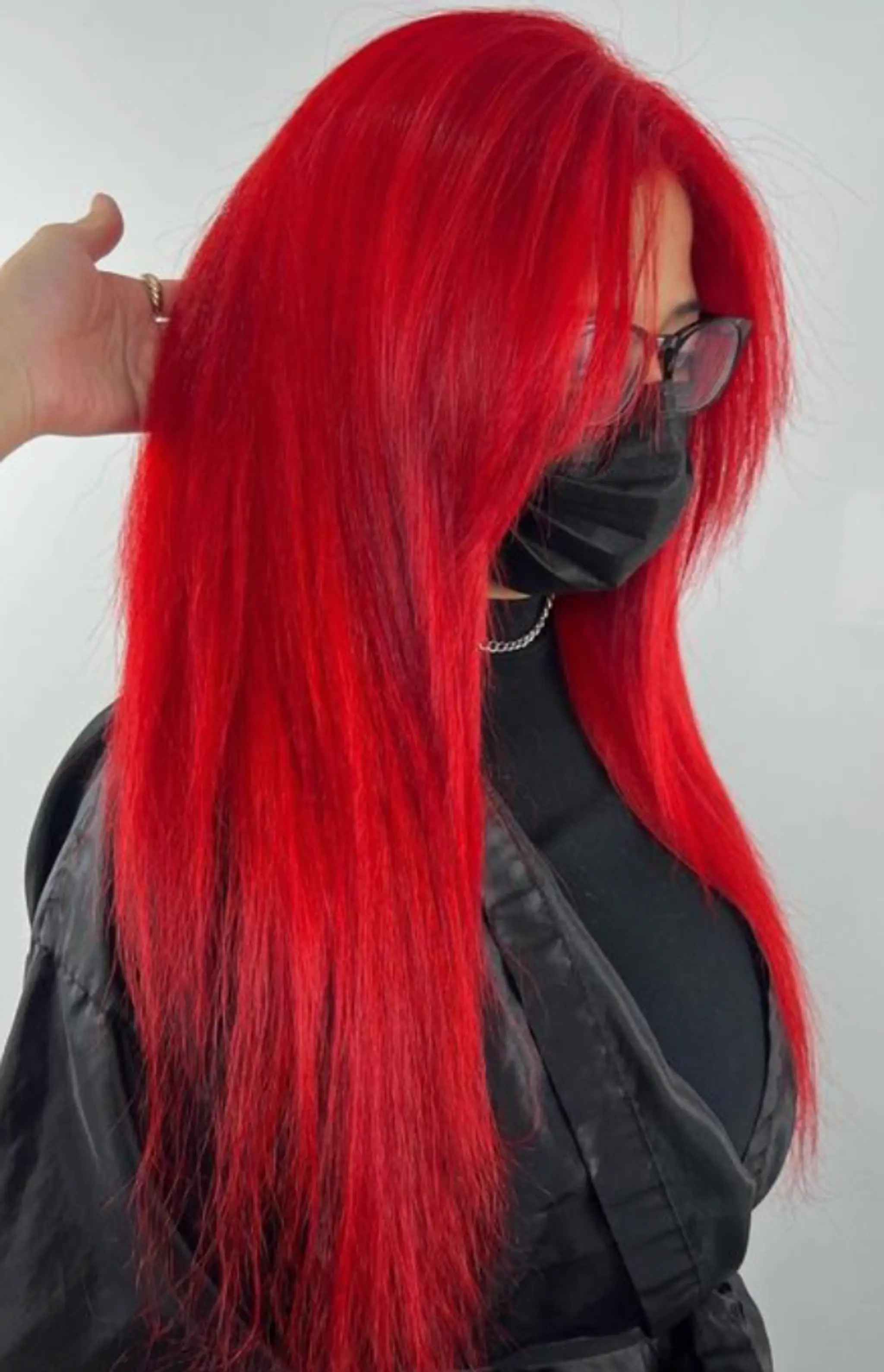 A stunning, very long straight hairstyle with a striking red color. The hair is meticulously styled, creating a smooth and sleek look. The vibrant red hue is bold and eye-catching, cascading down the back. The hair is full and voluminous, with a slight layering effect that adds dimension and movement. The ends are softly trimmed to create a polished finish.