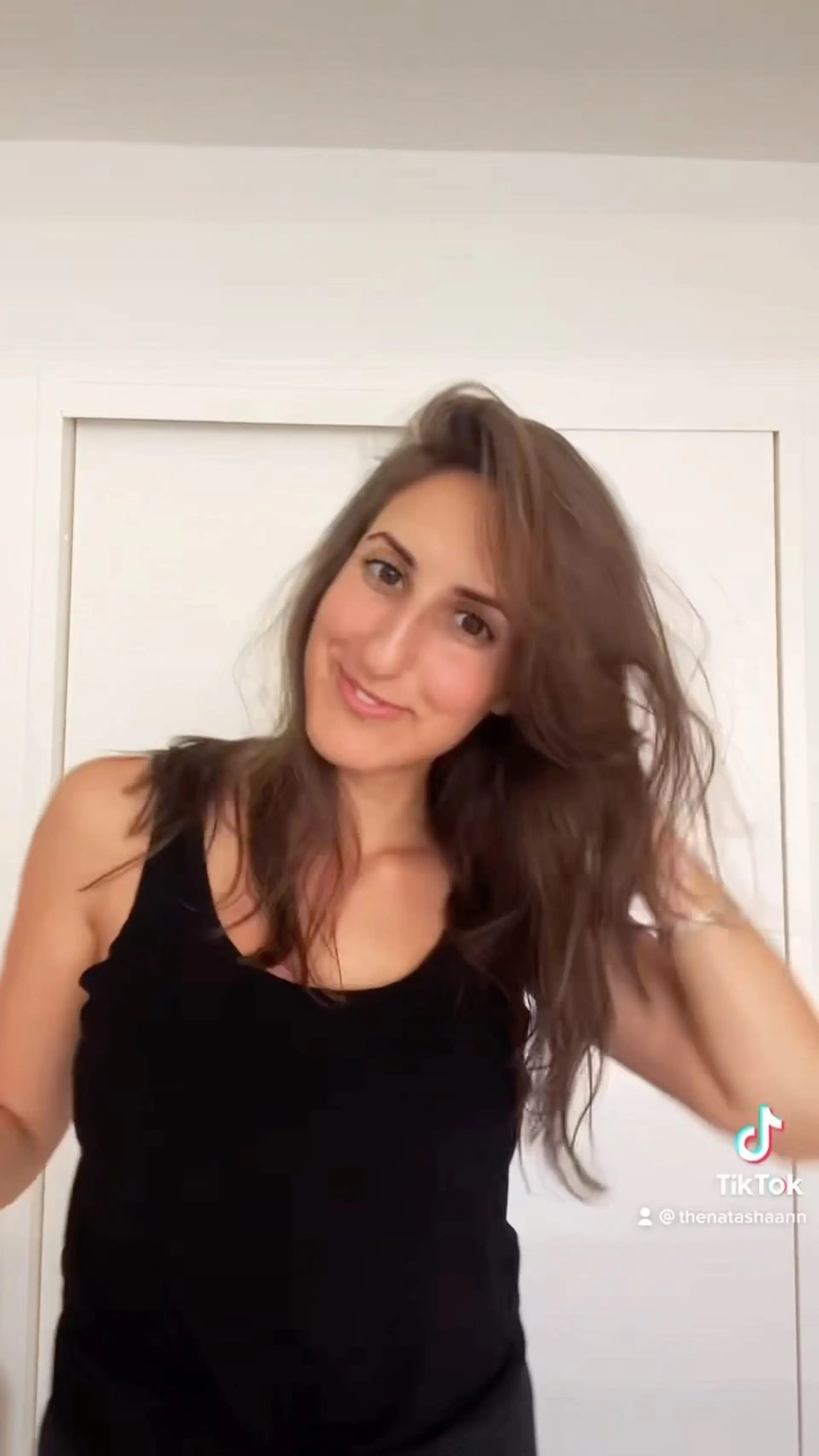 A long, tousled brunette haircut styled with soft body and natural movement. 1