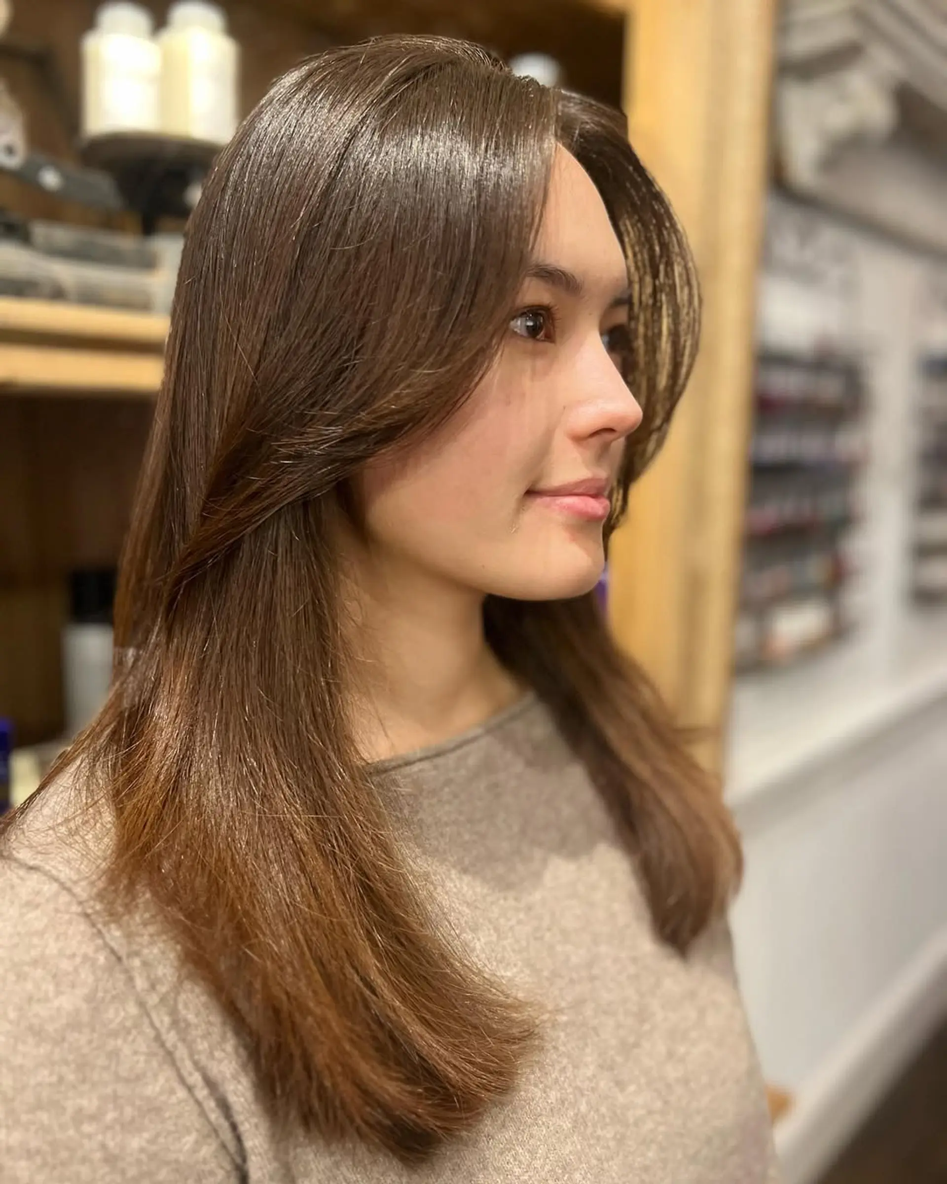 A long, straight hairstyle with chestnut brown color, featuring smooth layers, a middle part, and a glossy finish. 1