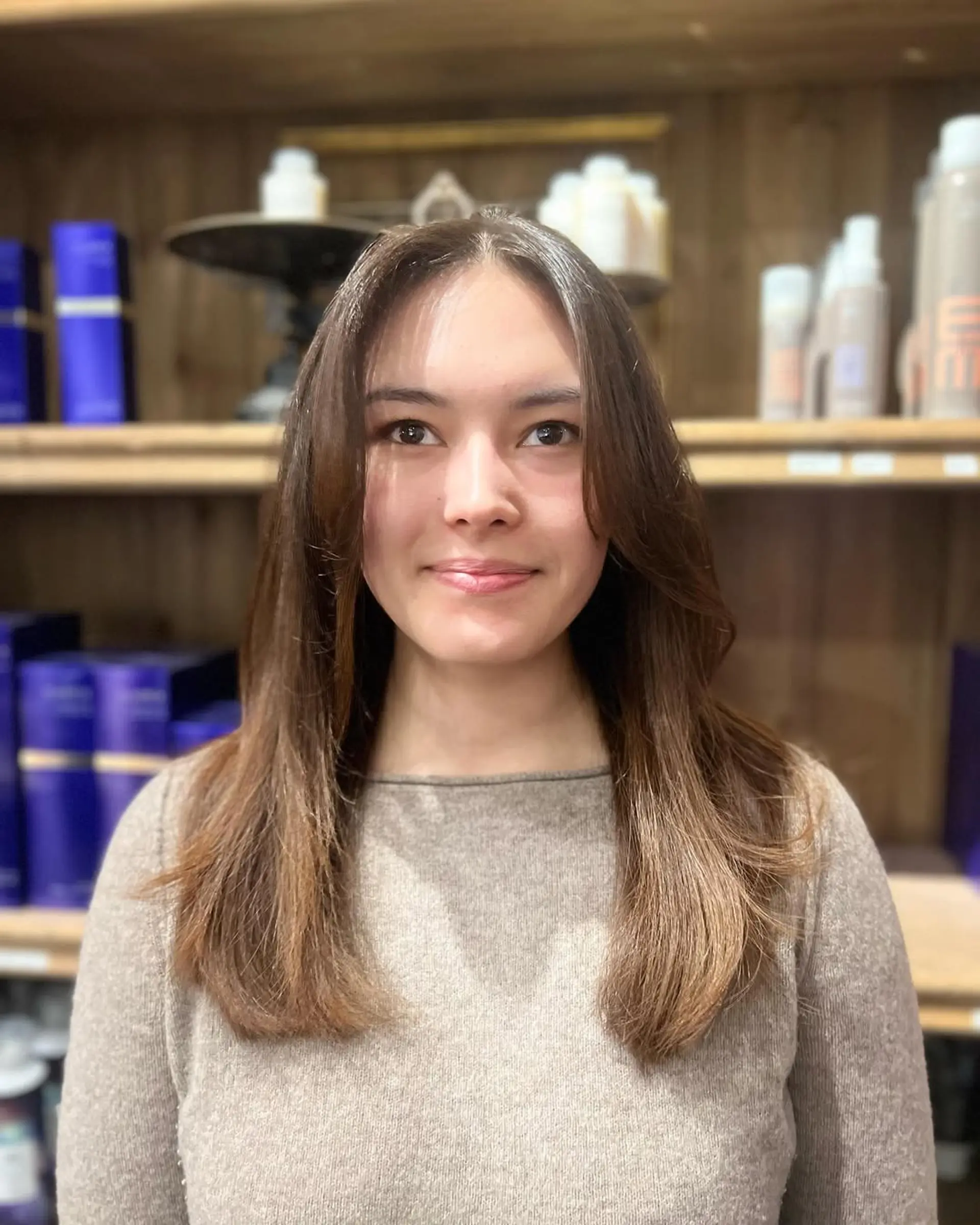 A long, straight hairstyle with chestnut brown color, featuring smooth layers, a middle part, and a glossy finish. 2