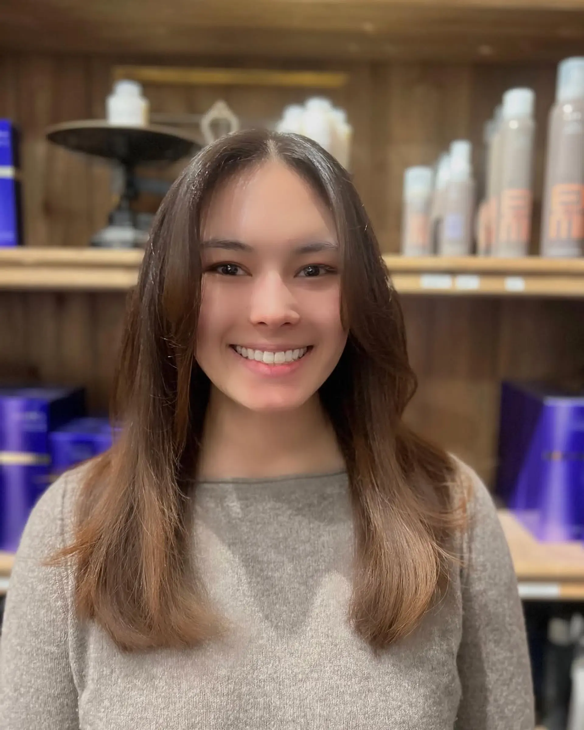 A long, straight hairstyle with chestnut brown color, featuring smooth layers, a middle part, and a glossy finish. 3