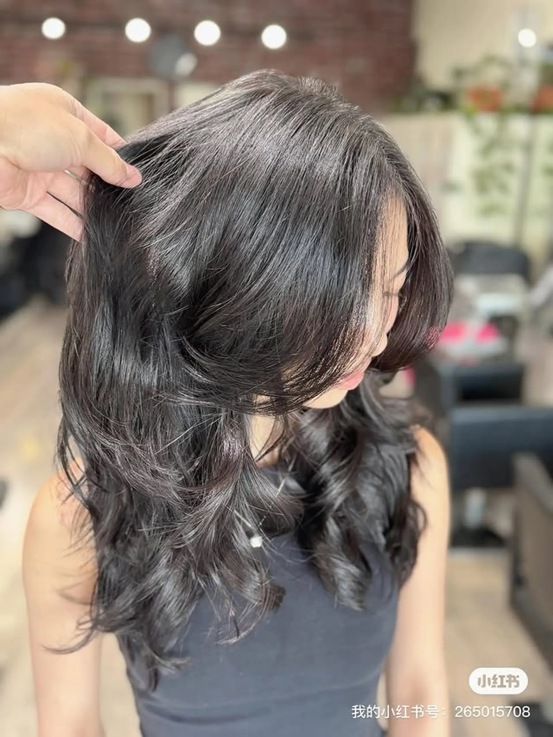 A voluminous long layered cut featuring prominent face-framing layers that create a butterfly-like effect. The style enhances natural waves, adding significant body and movement, with layers cascading from the mid-length to the ends. 1