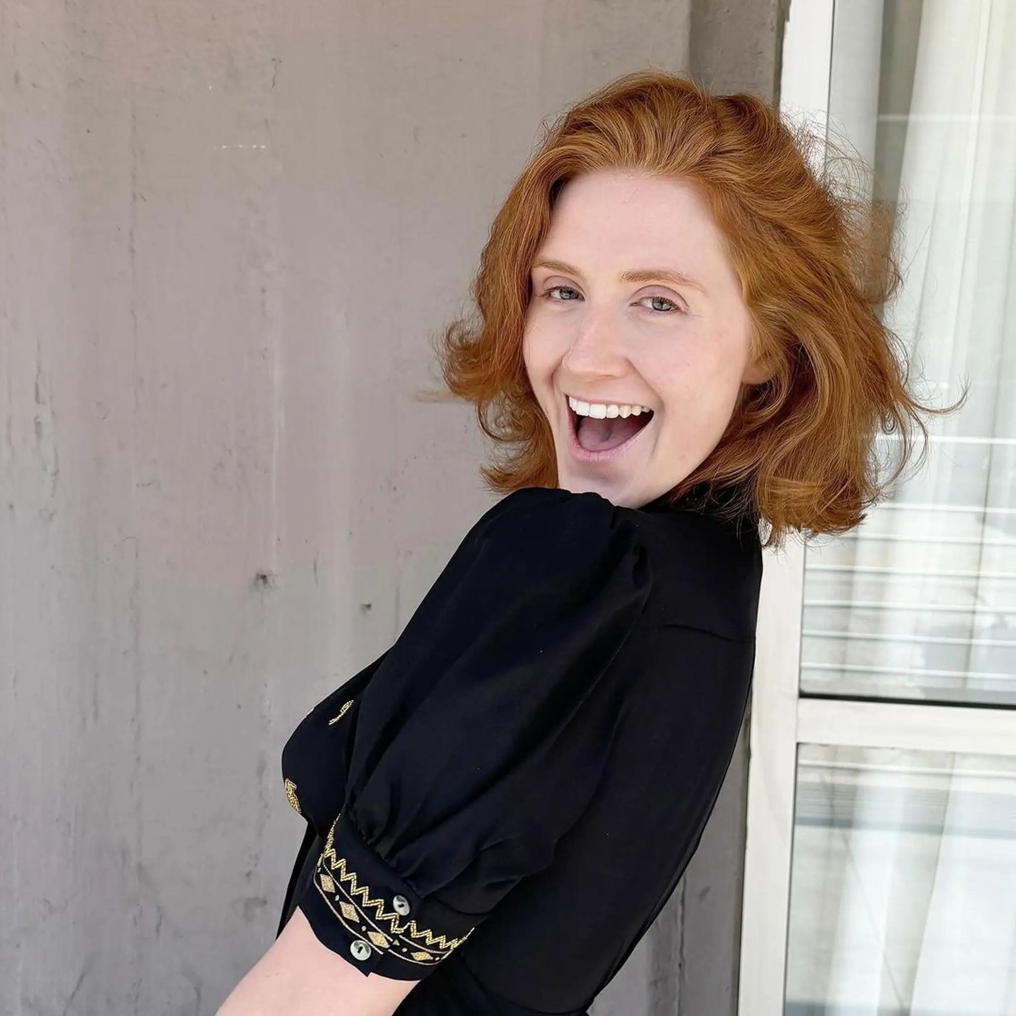 A medium-length, wavy hairstyle with a vibrant red color, featuring natural waves and soft layers for added volume and movement. The overall look is voluminous and rich in body.