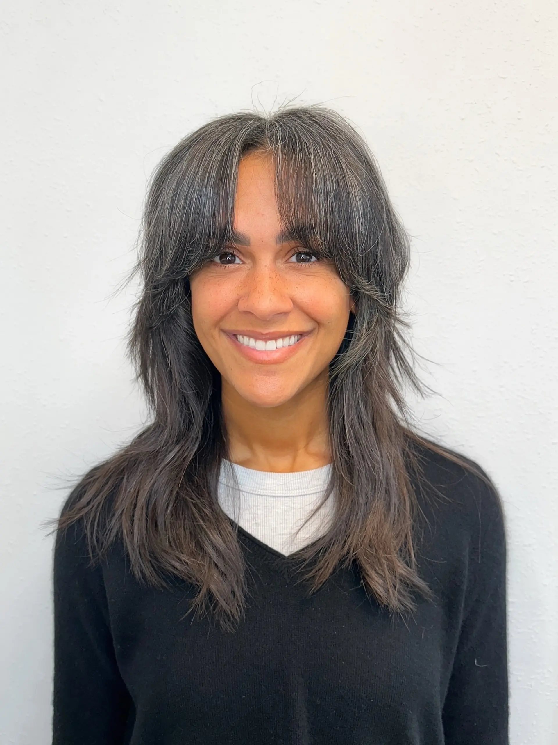A layered, modern shag haircut featuring curtain bangs and piecey, feathered face-framing texture. 1