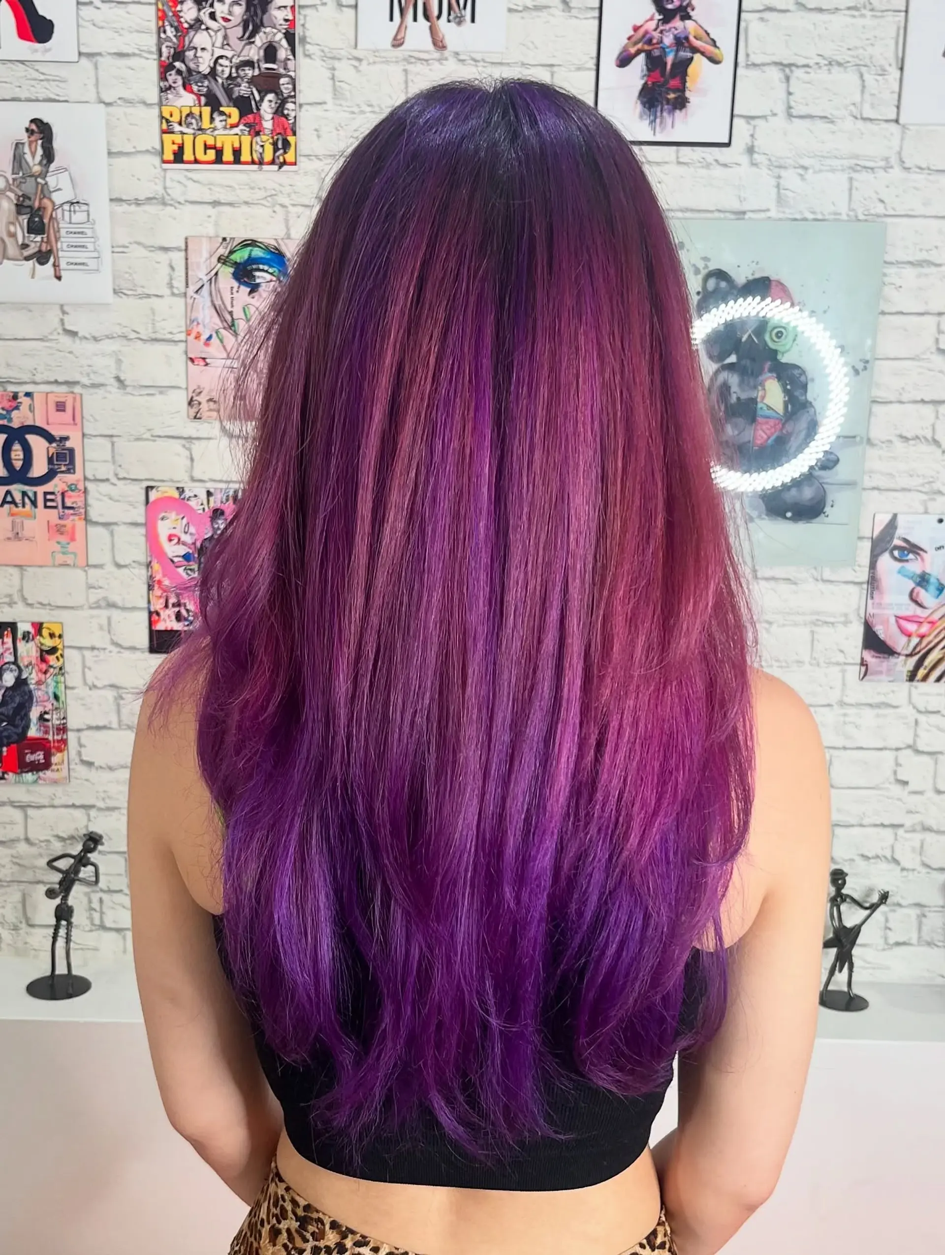 A medium-length layered haircut with face-framing layers, styled with a vibrant purple and burgundy color combination. 3