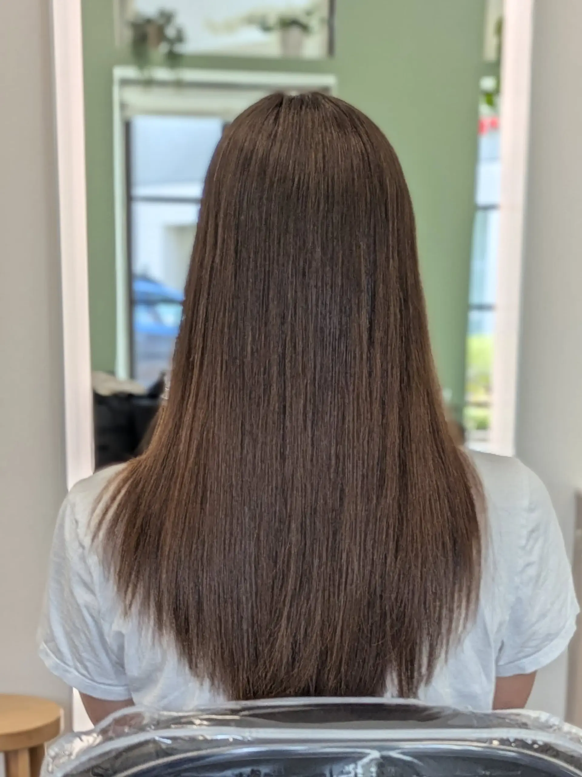 Long, pin-straight brunette hair with a smooth, glossy finish following a Japanese straightening treatment. 1