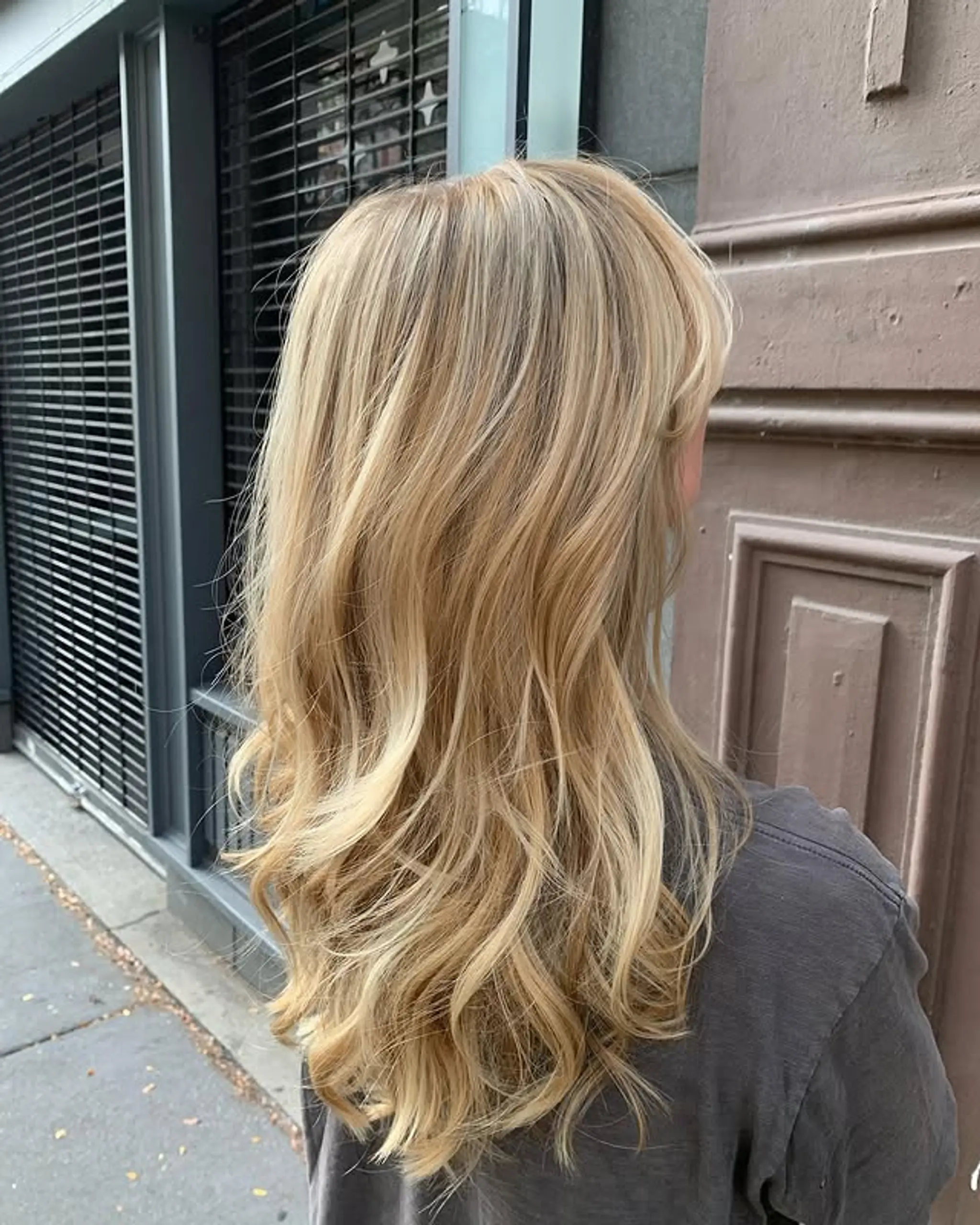 Long, layered wavy hair with beachy waves and blonde highlights.