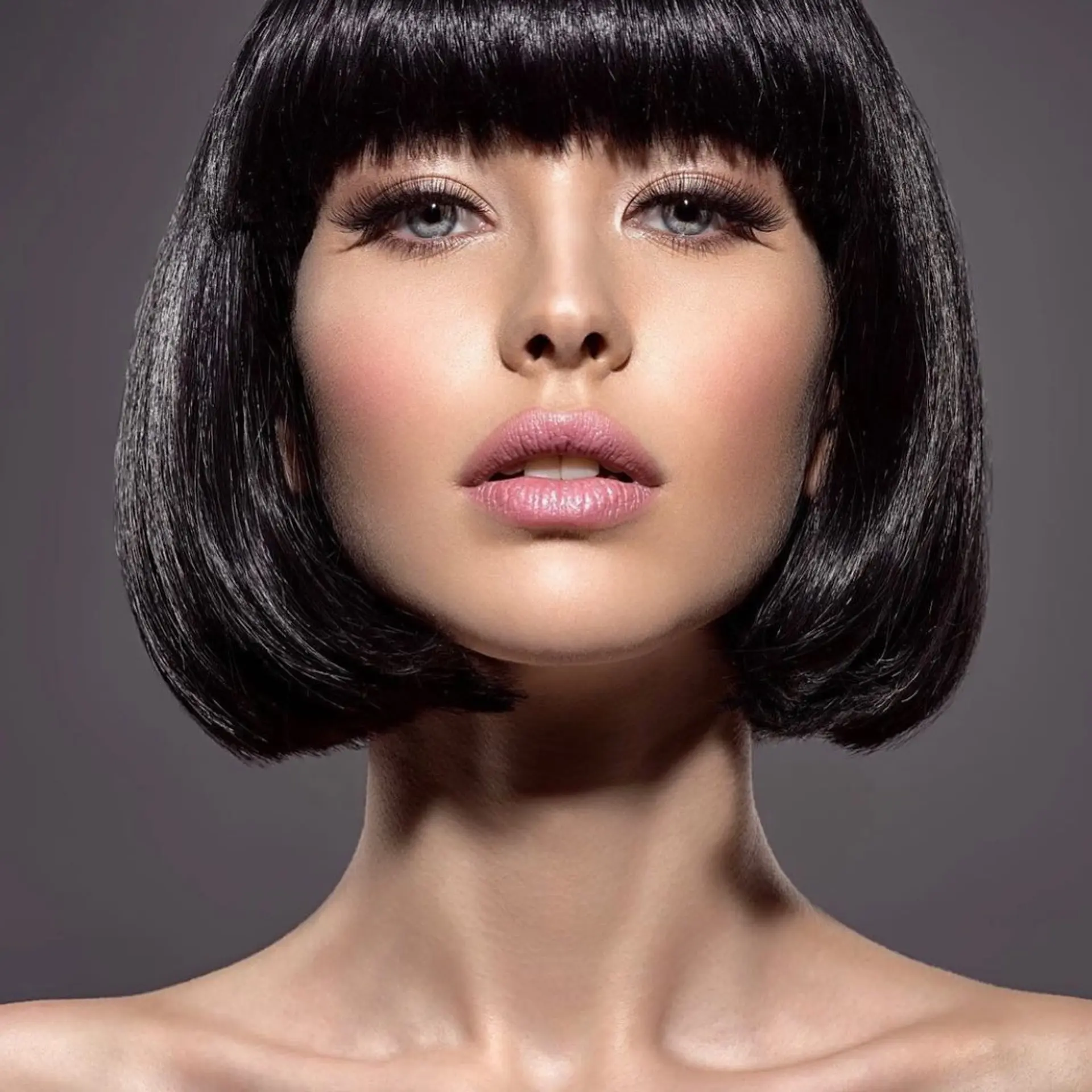 A sleek, chin-length jet black bob featuring rounded ends and full, straight-across bangs. 1