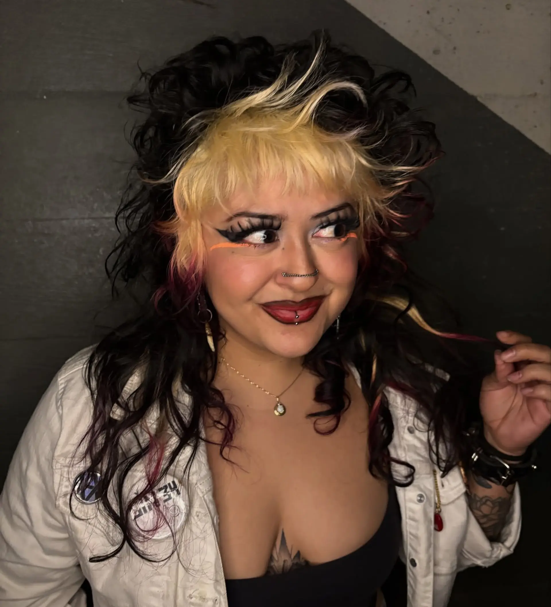 A voluminous curly shag mullet featuring a bleached blonde fringe and front panels finished with vivid raspberry tips. 1