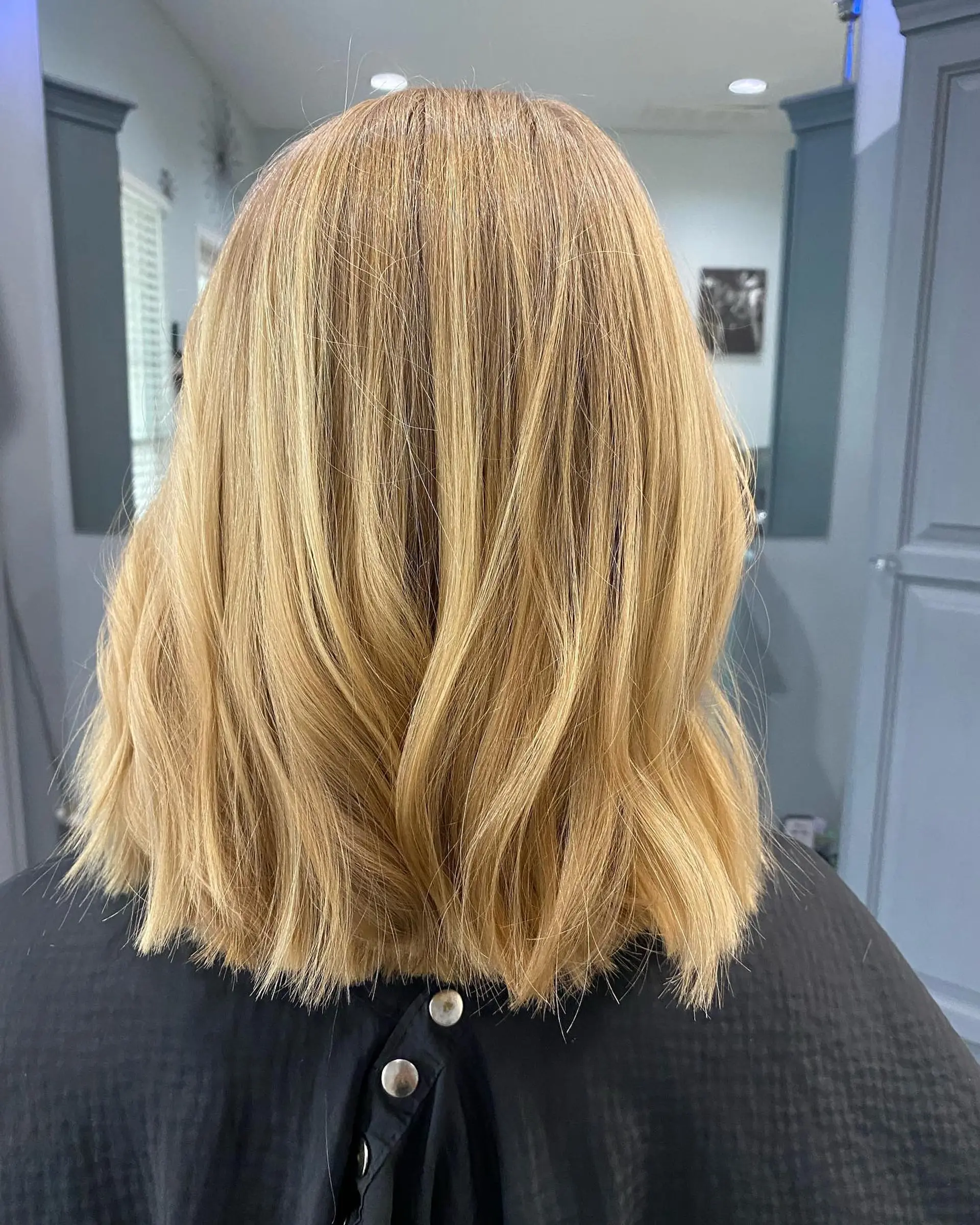 A blunt, collarbone-length lob haircut with textured ends on warm golden blonde hair. 1