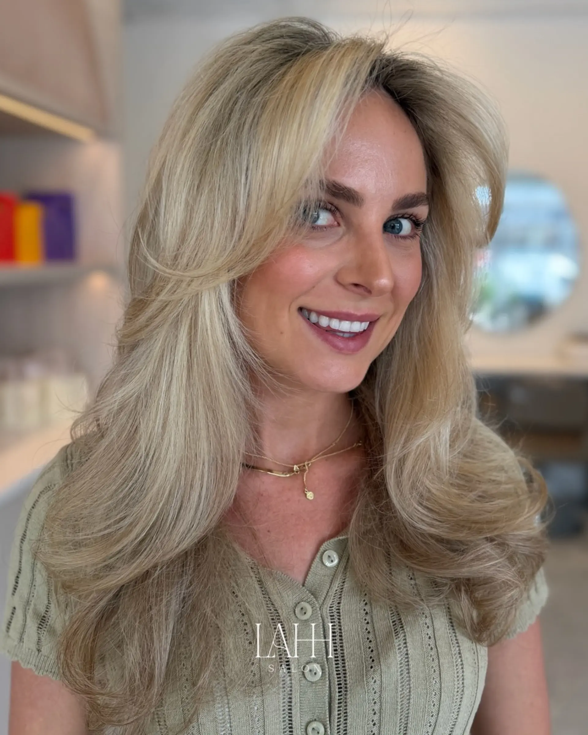A glamorous, voluminous blowout on long dimensional blonde hair with soft, layered movement. 1