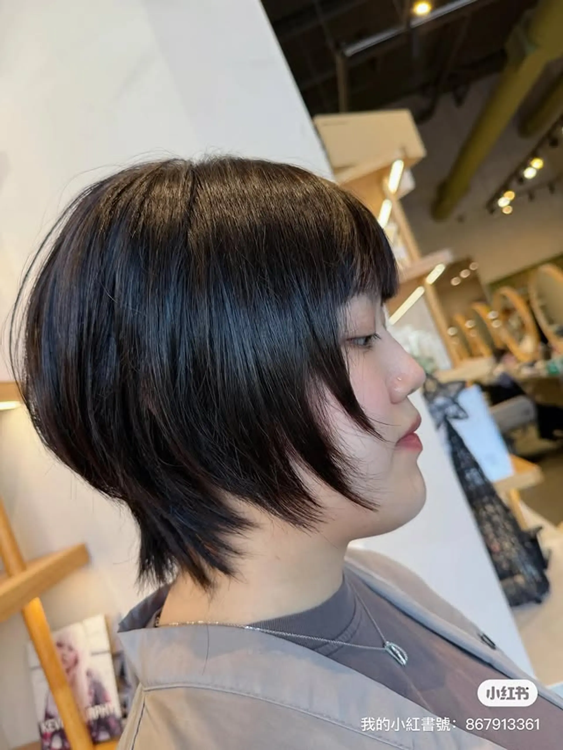 A short layered bob with blunt bangs and subtle face-framing layers. 1