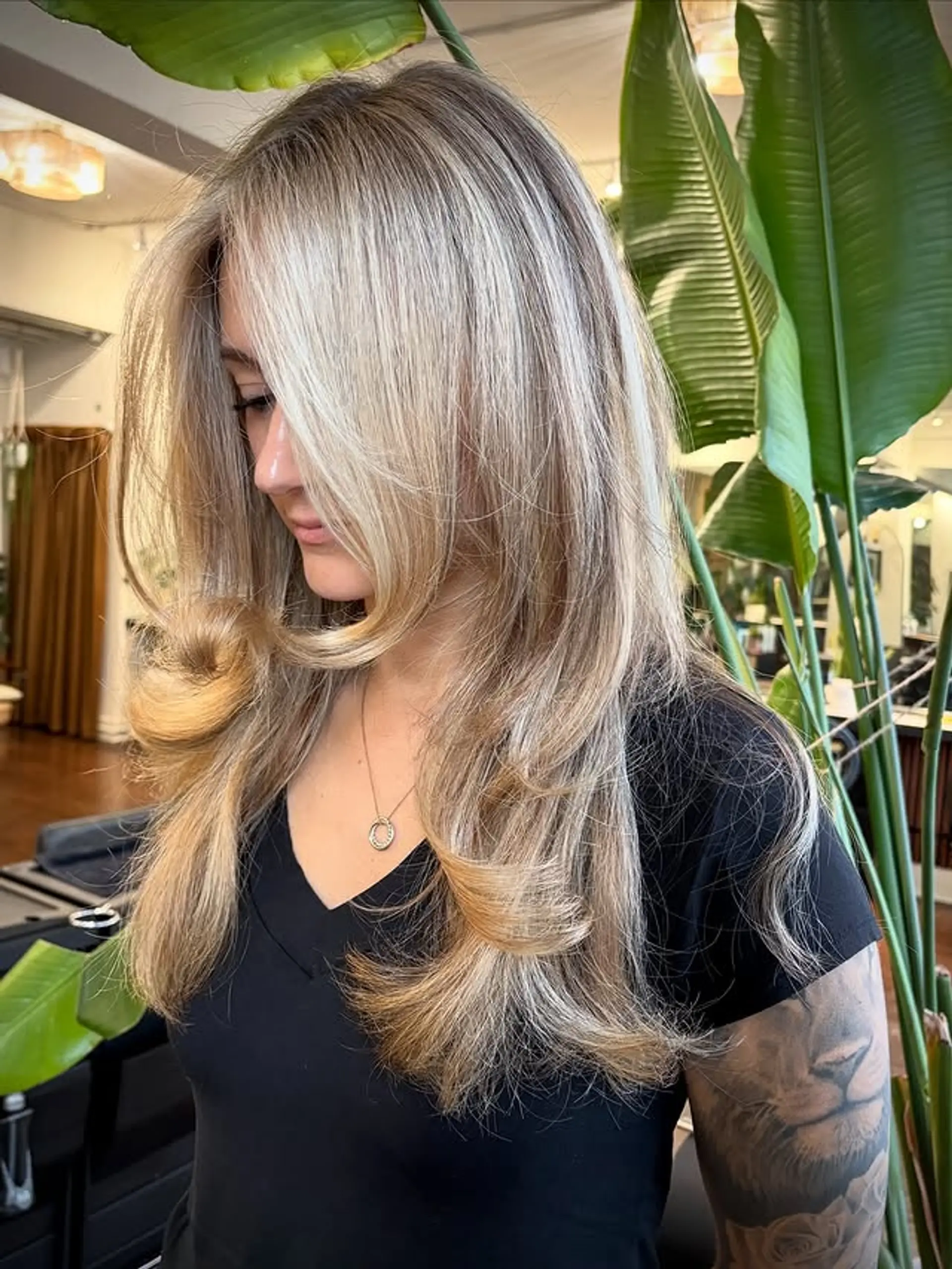 A medium-length layered hairstyle with face-framing layers and a warm blonde color. 1