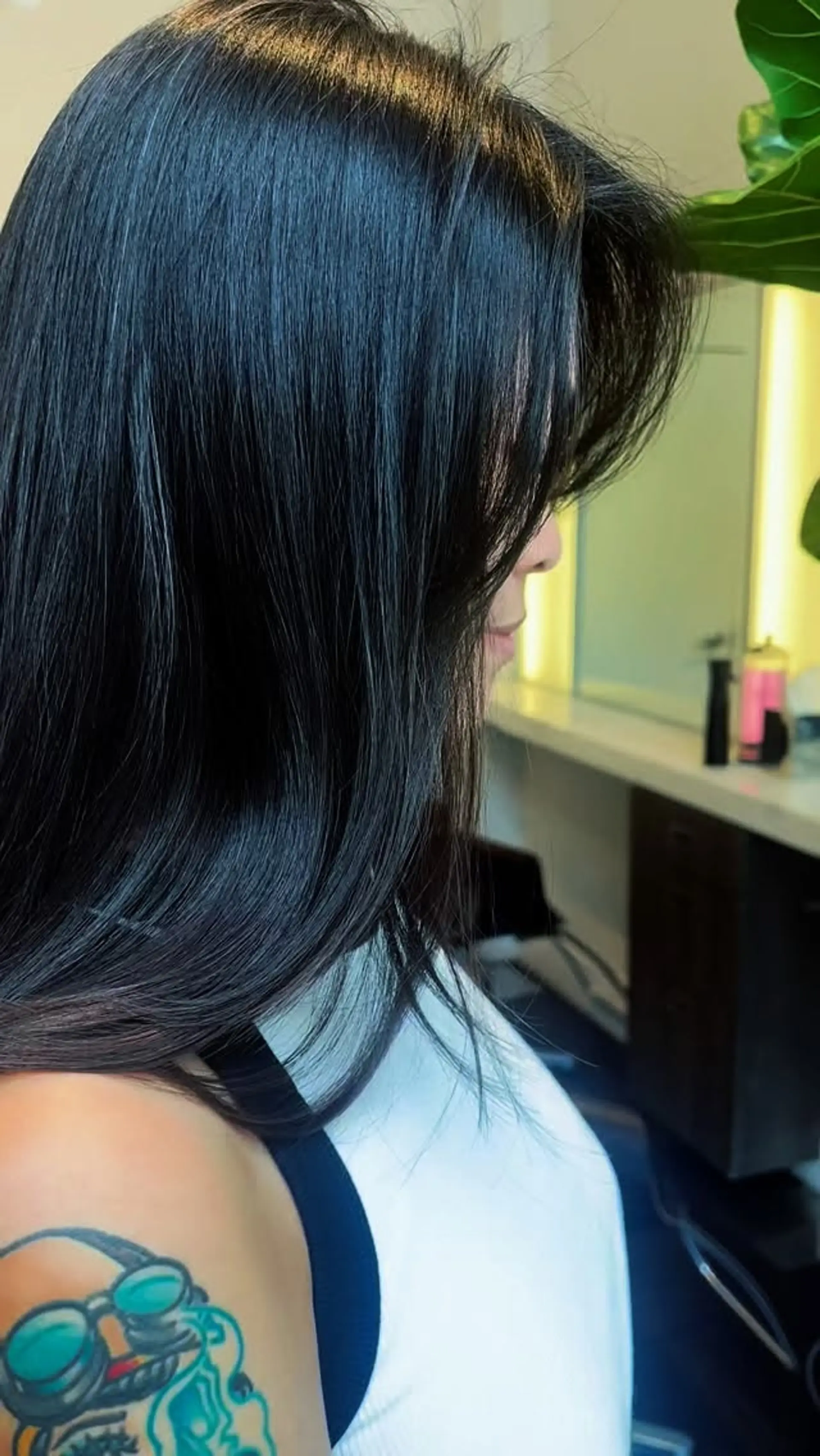 A sleek, glossy black haircut featuring soft, face-framing bangs and smoothly styled layers. 1