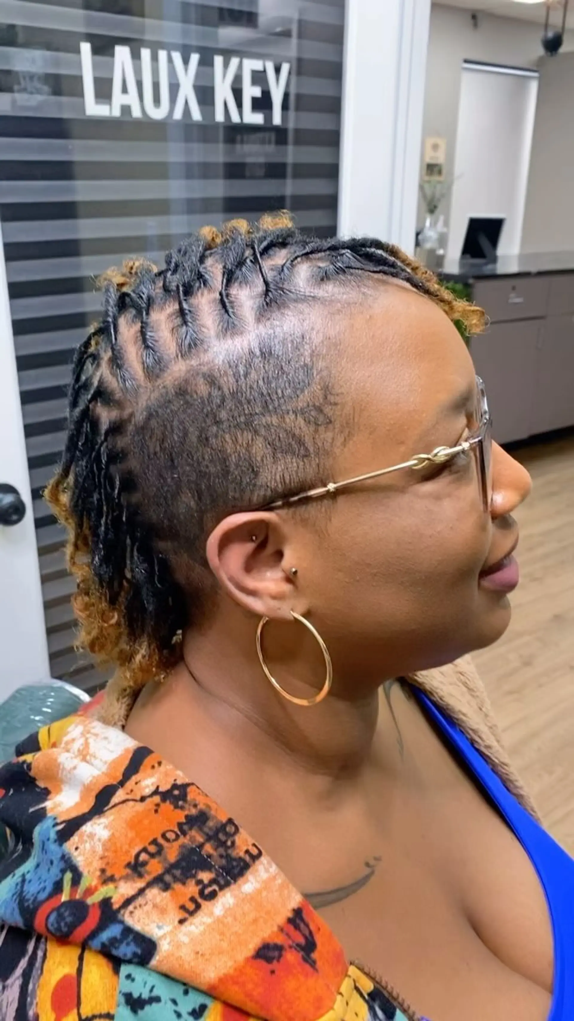 A sleek loc mohawk featuring neatly retwisted dreadlocks centered along the crown with blonde tips, paired with closely tapered shaved sides. 1