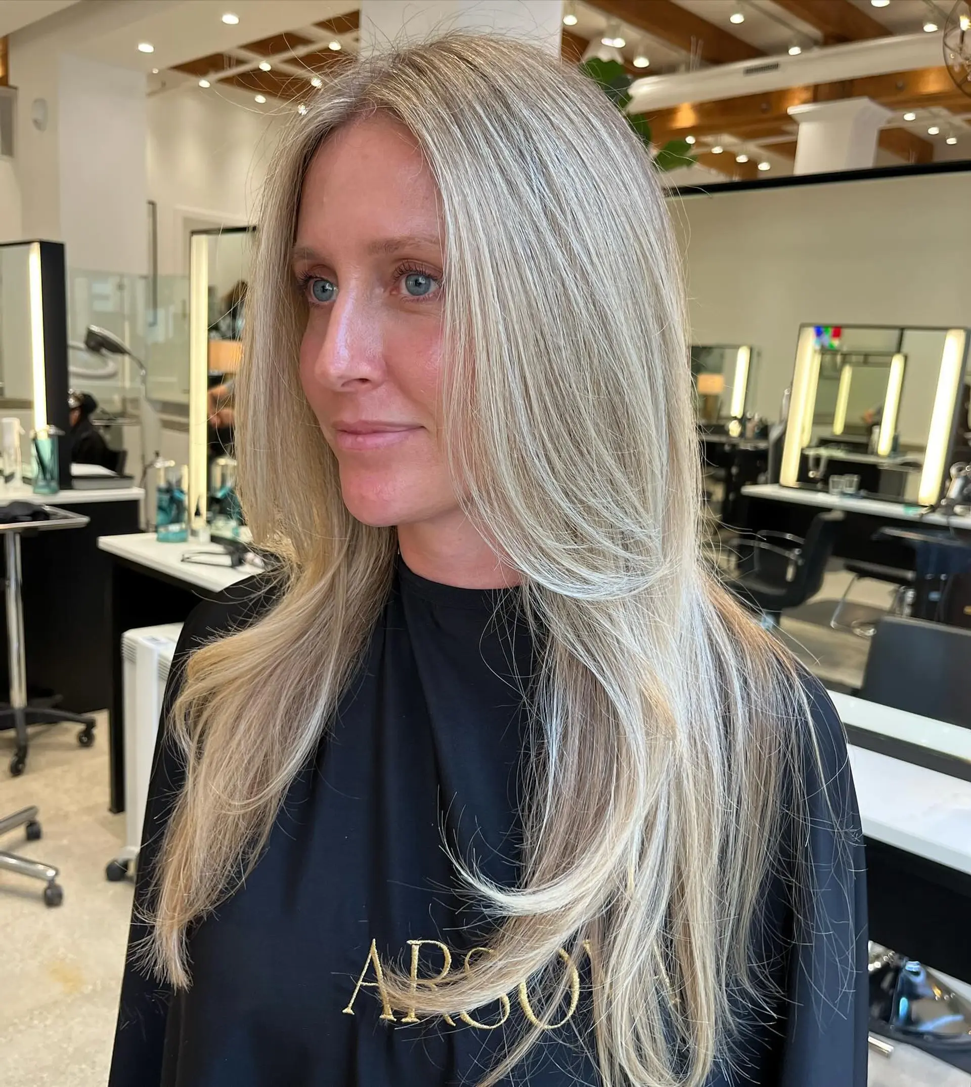 A long, straight hairstyle with layers and icy blonde balayage. 1