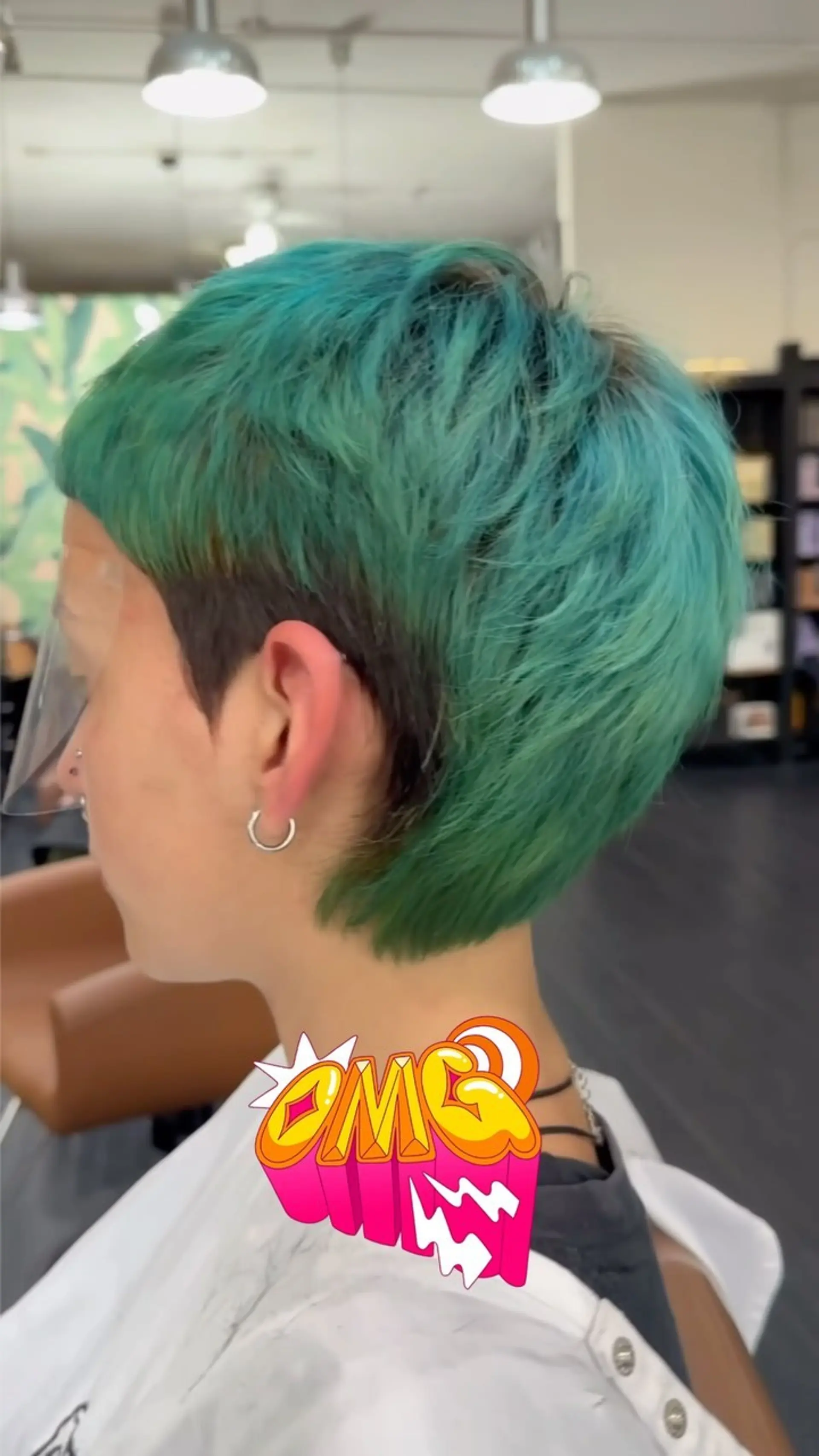 A bold short pixie-mullet with vivid teal-green layers contrasted against a dark tapered undercut. 1
