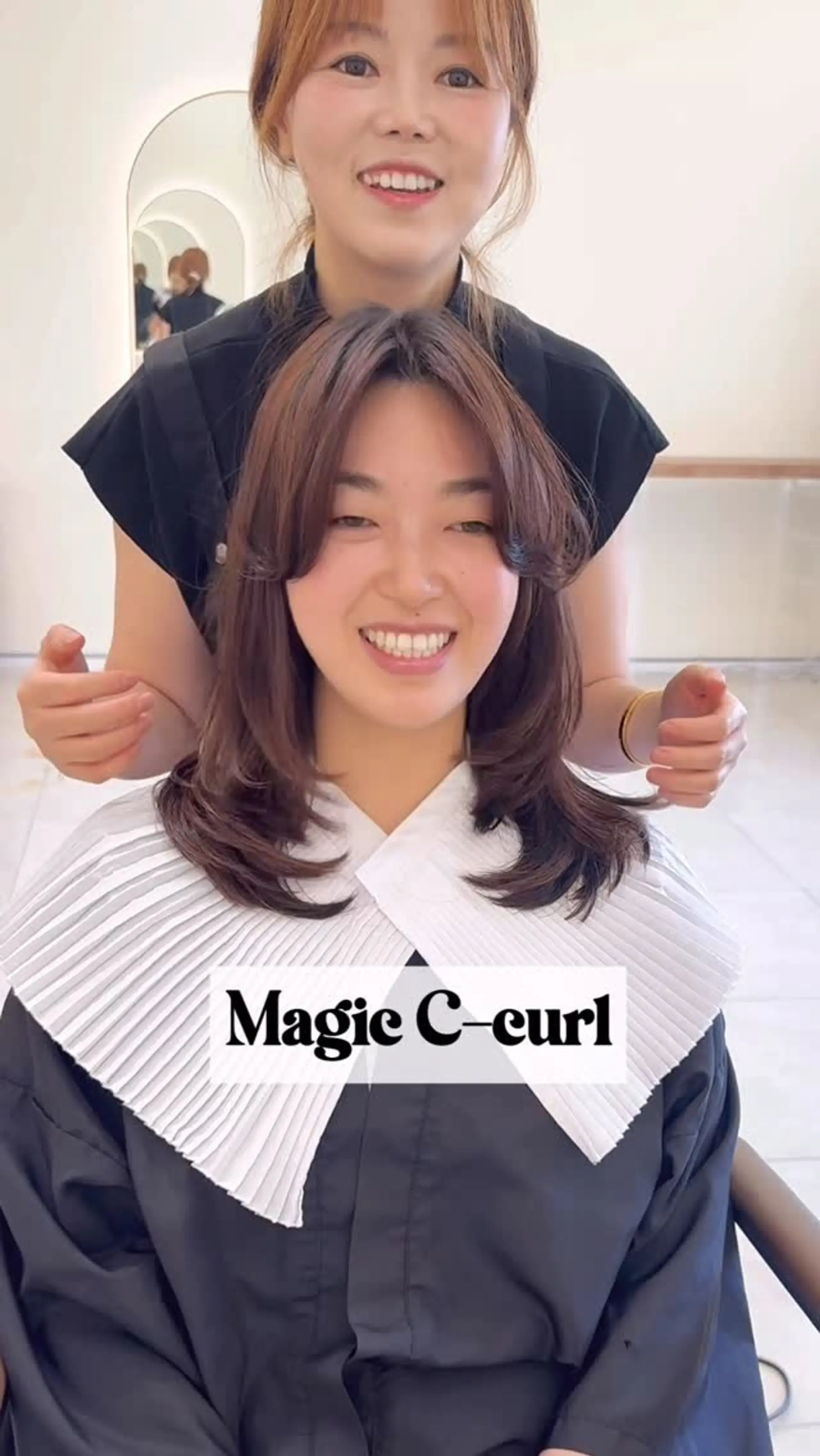 Shoulder-length layered cut styled with a Korean magic C-curl perm and face-framing curtain bangs. 1