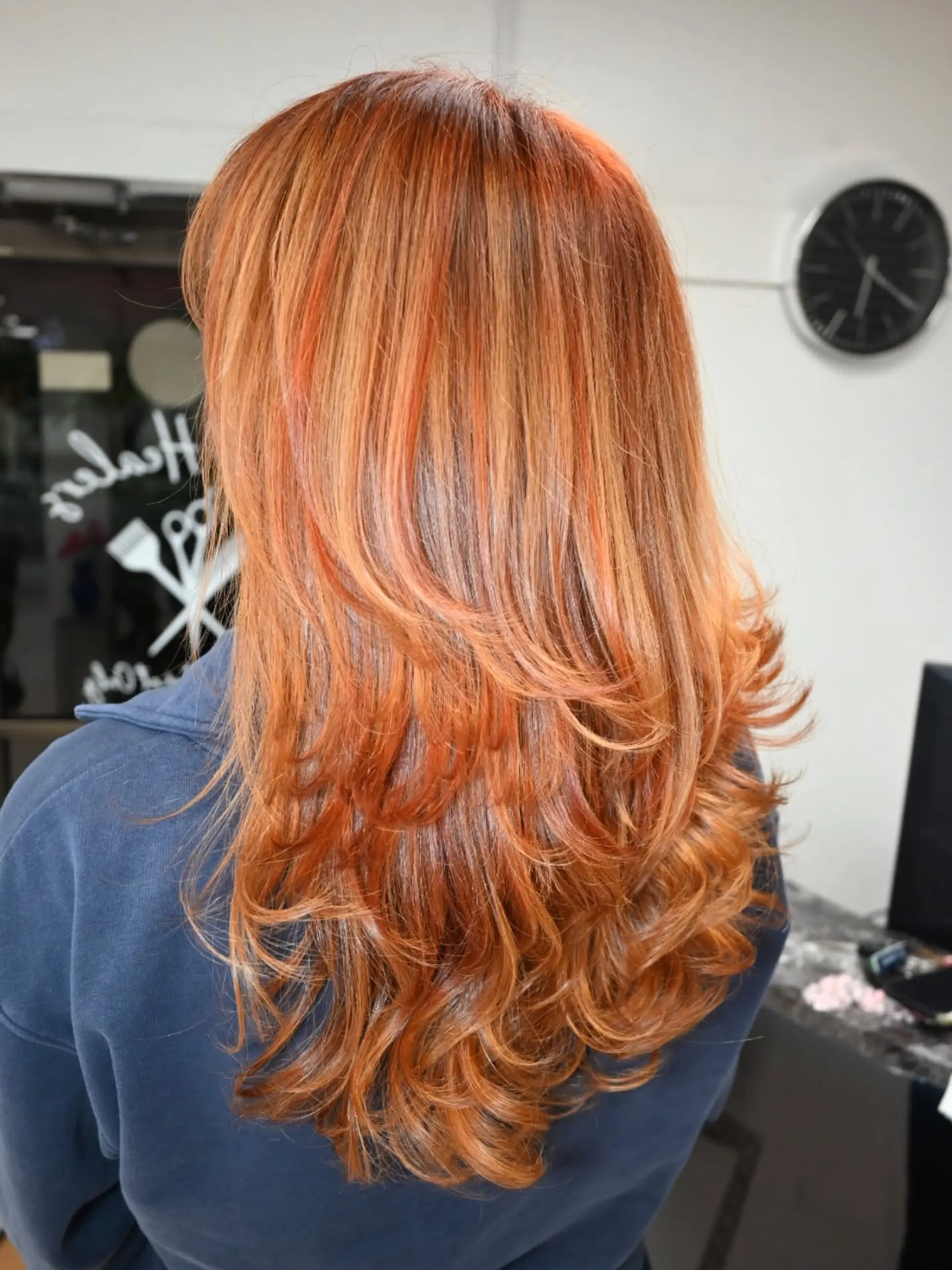 Long layered copper hair styled with voluminous feathered layers and soft, curled ends. 1
