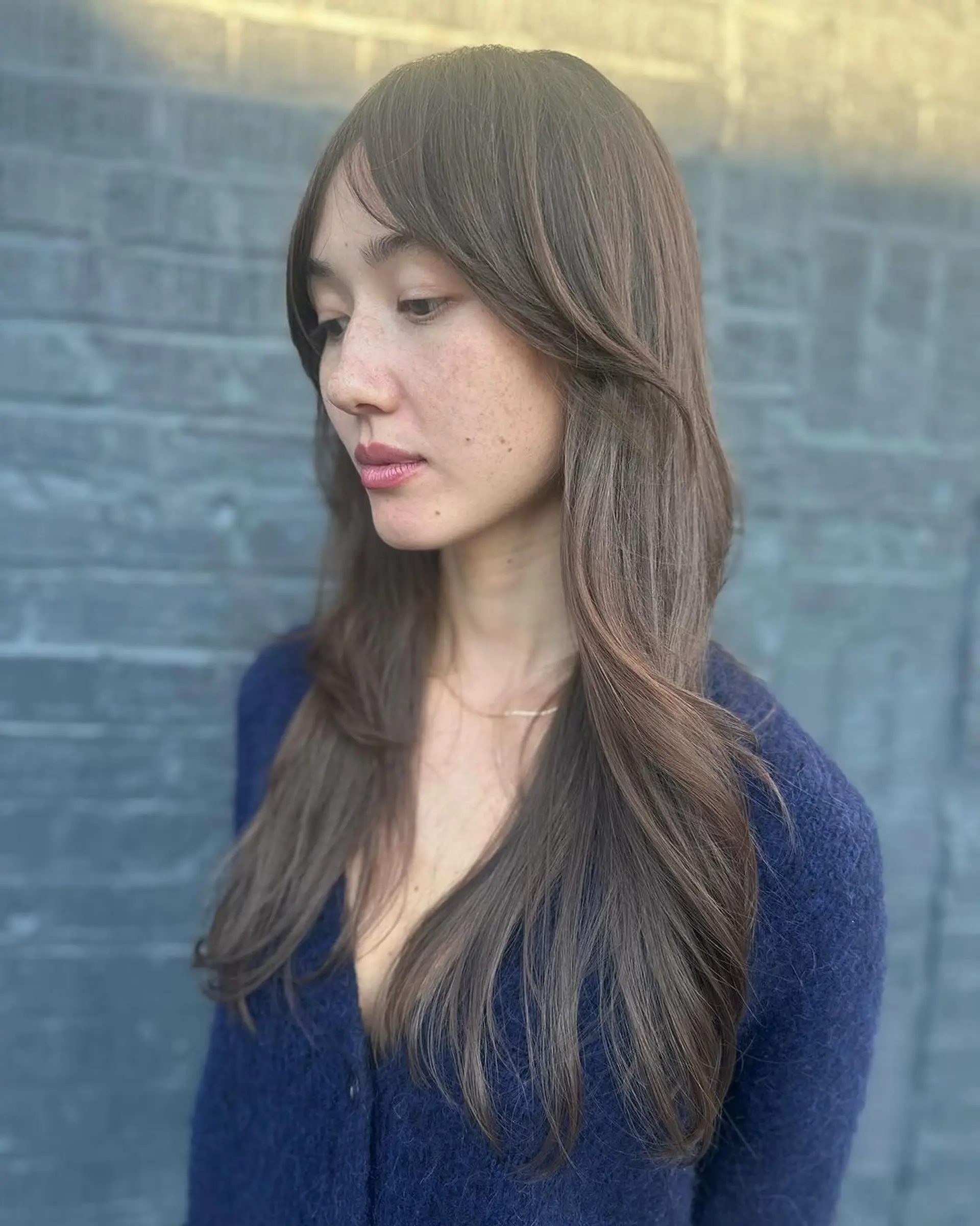 Long, dark brown wavy hair with soft layers, face-framing sections, natural shine, and feathered ends. 2