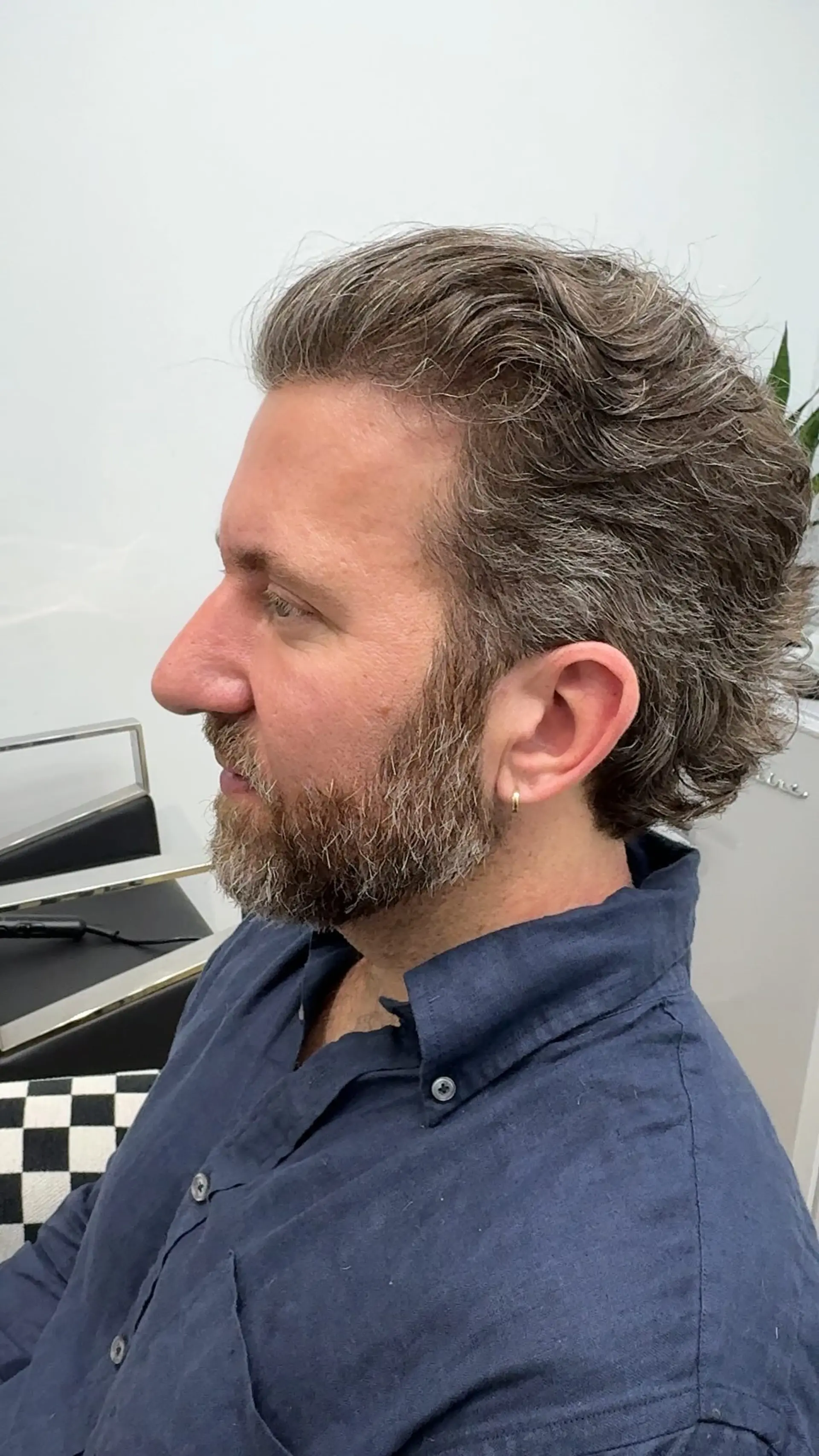 A subtle modern mullet featuring tapered sides and longer, textured waves flowing toward the back. 1