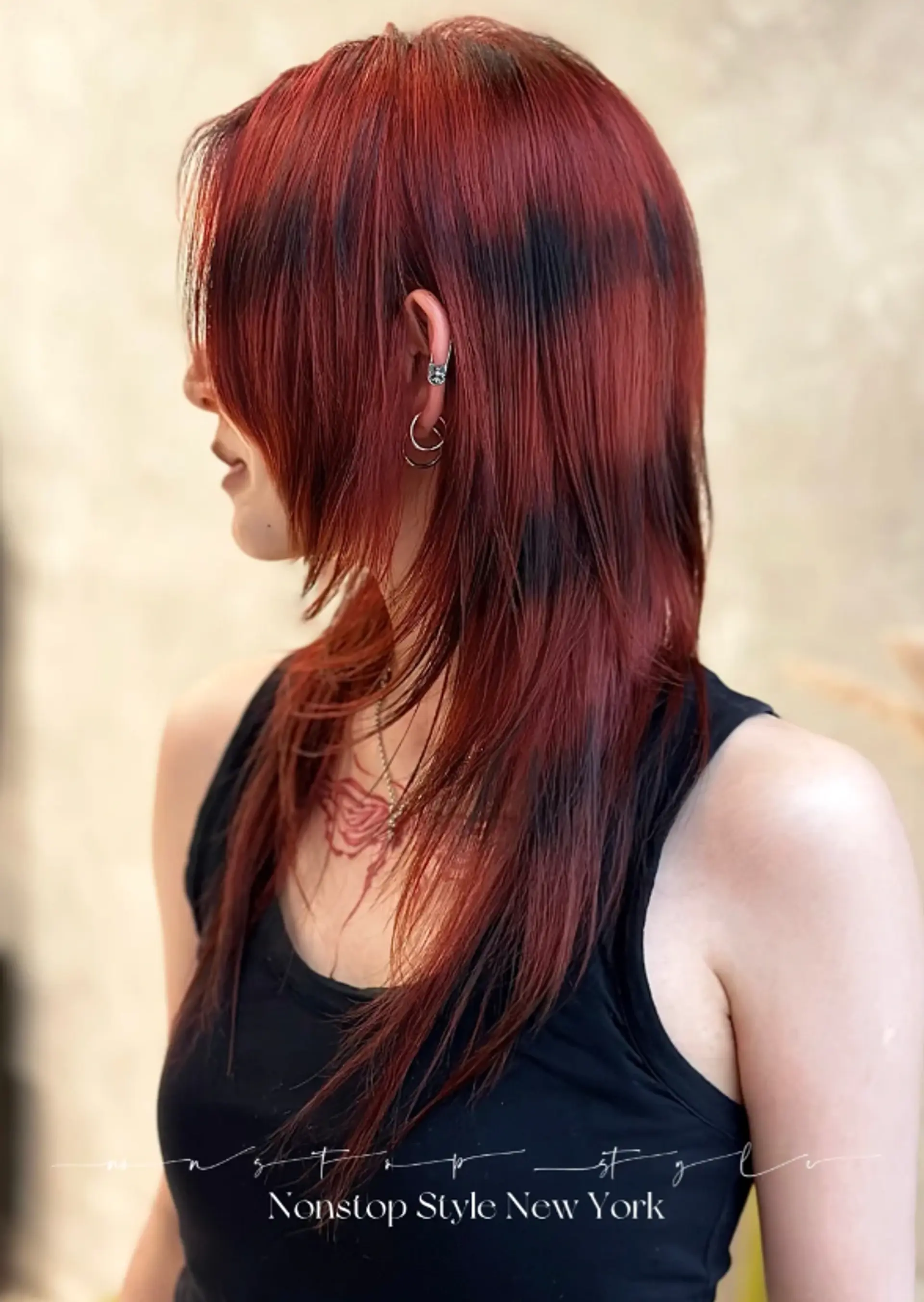 An edgy and bold hairstyle characterized by deep, layered cuts that cascade down to below the shoulders. The hair texture is straight, with a predominant color of striking red accented with dark brown highlights. Layers are well-defined, especially around the face, using a razor-cut technique for an added modern vibe.
(NonstopStyle: by Hsing Hoo) 1