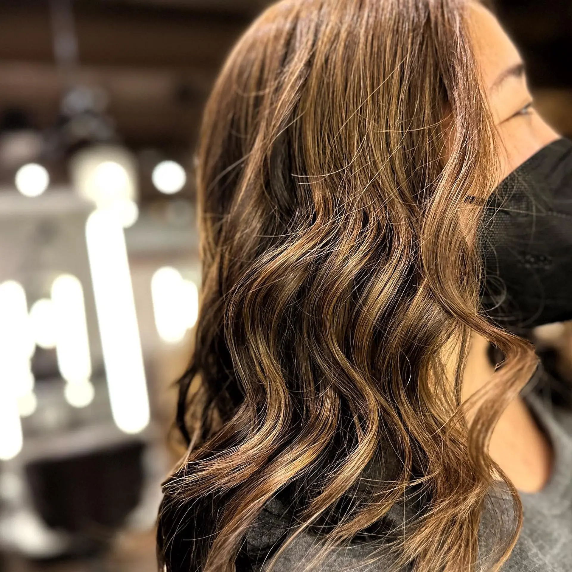 A medium-length wavy hairstyle with a caramel balayage. 1