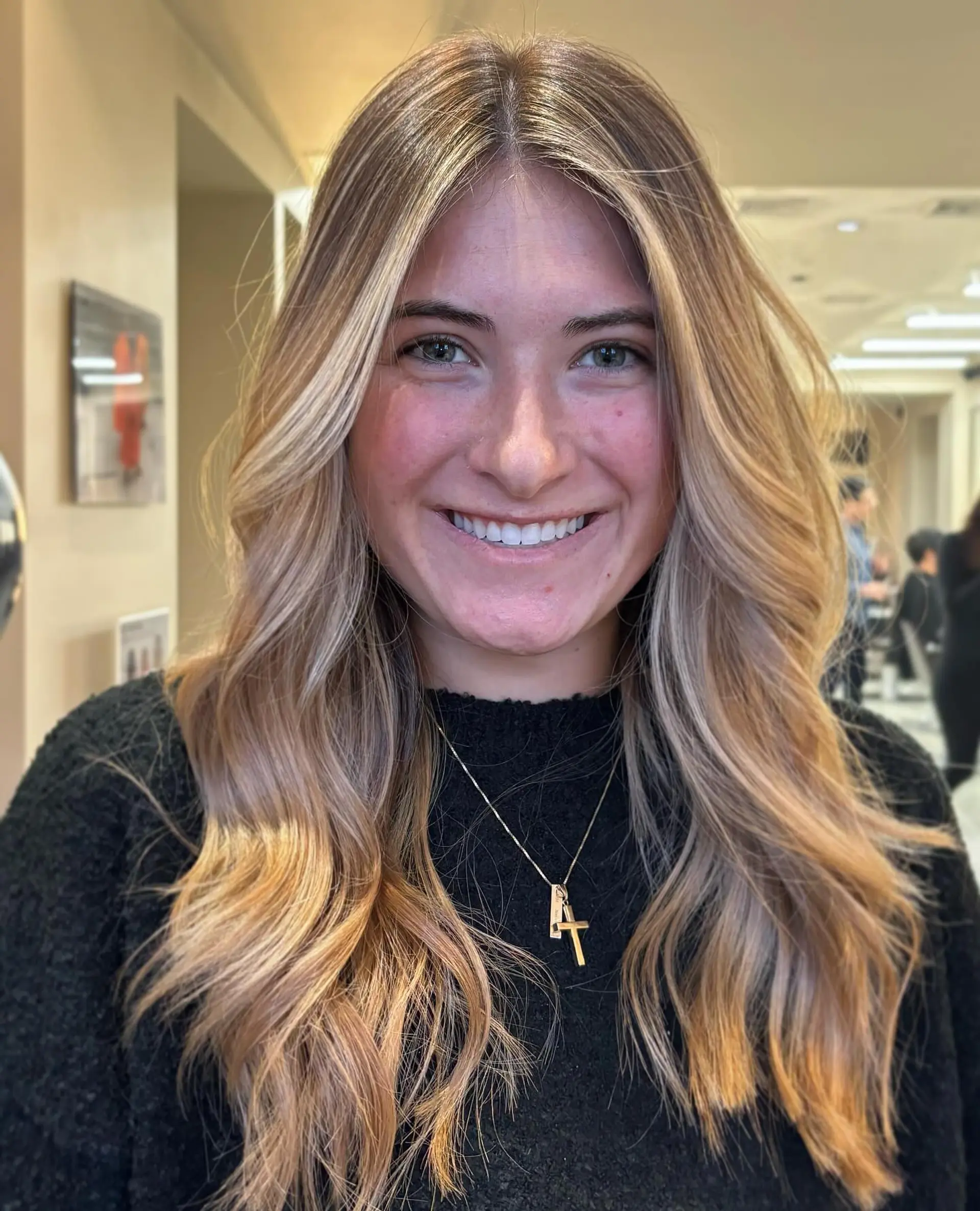 Long dimensional bronde hair with seamless blonde highlights and soft, face-framing blowout waves. 1