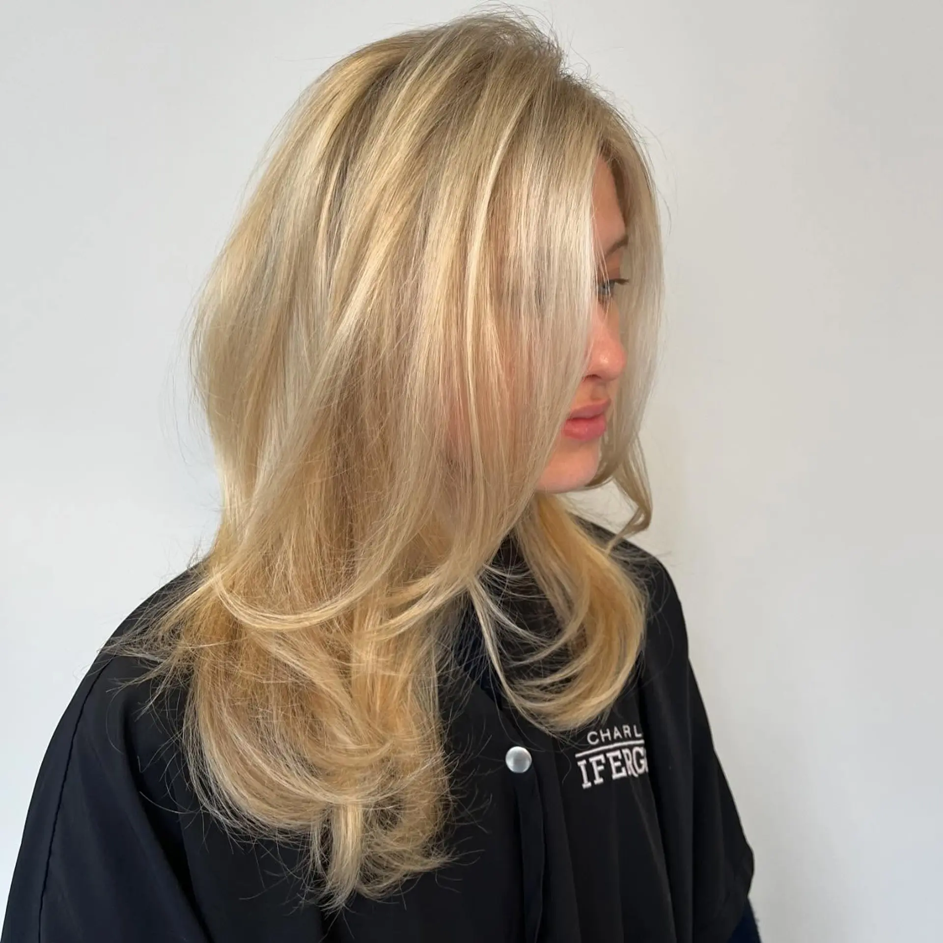 A bright butter blonde style featuring long face-framing layers and a bouncy, voluminous blowout. 1