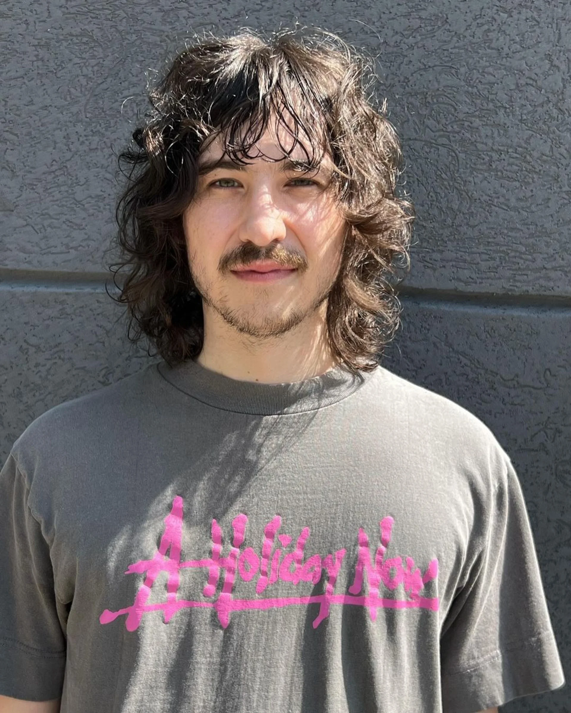 Medium-length curly hair styled in a relaxed bro flow with a naturally tapered neckline - Preview 1