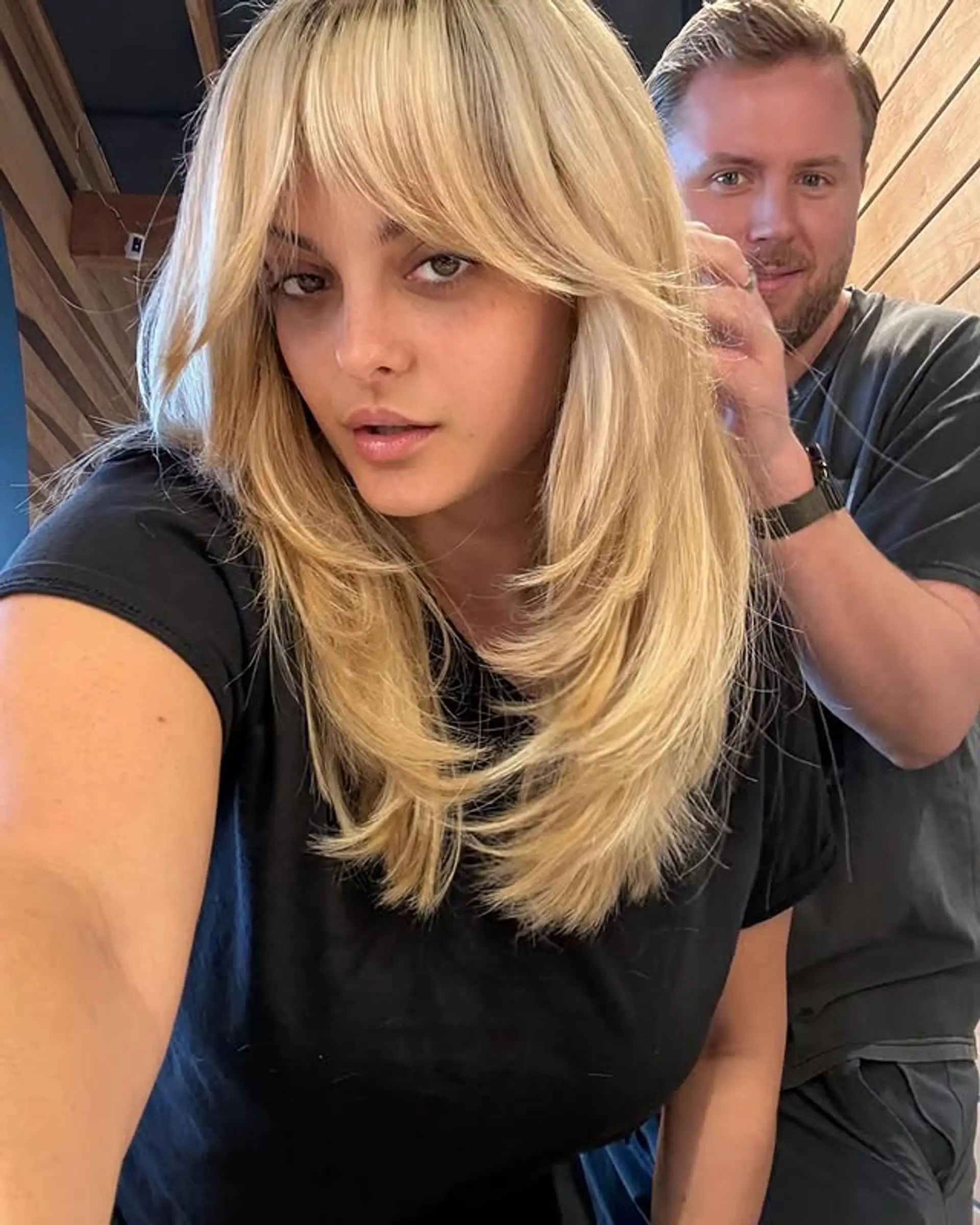 A medium length hairstyle featuring long layers and face-framing curtain bangs. 1