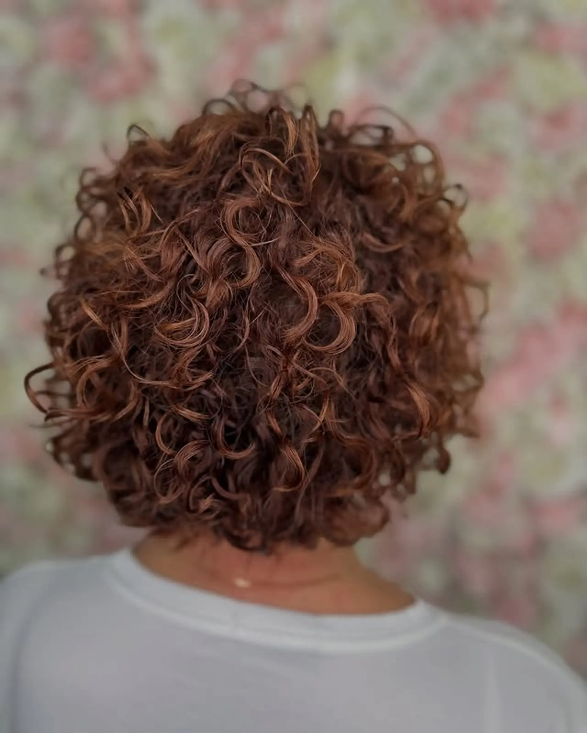 A short, curly bob with defined curls and highlights. 1