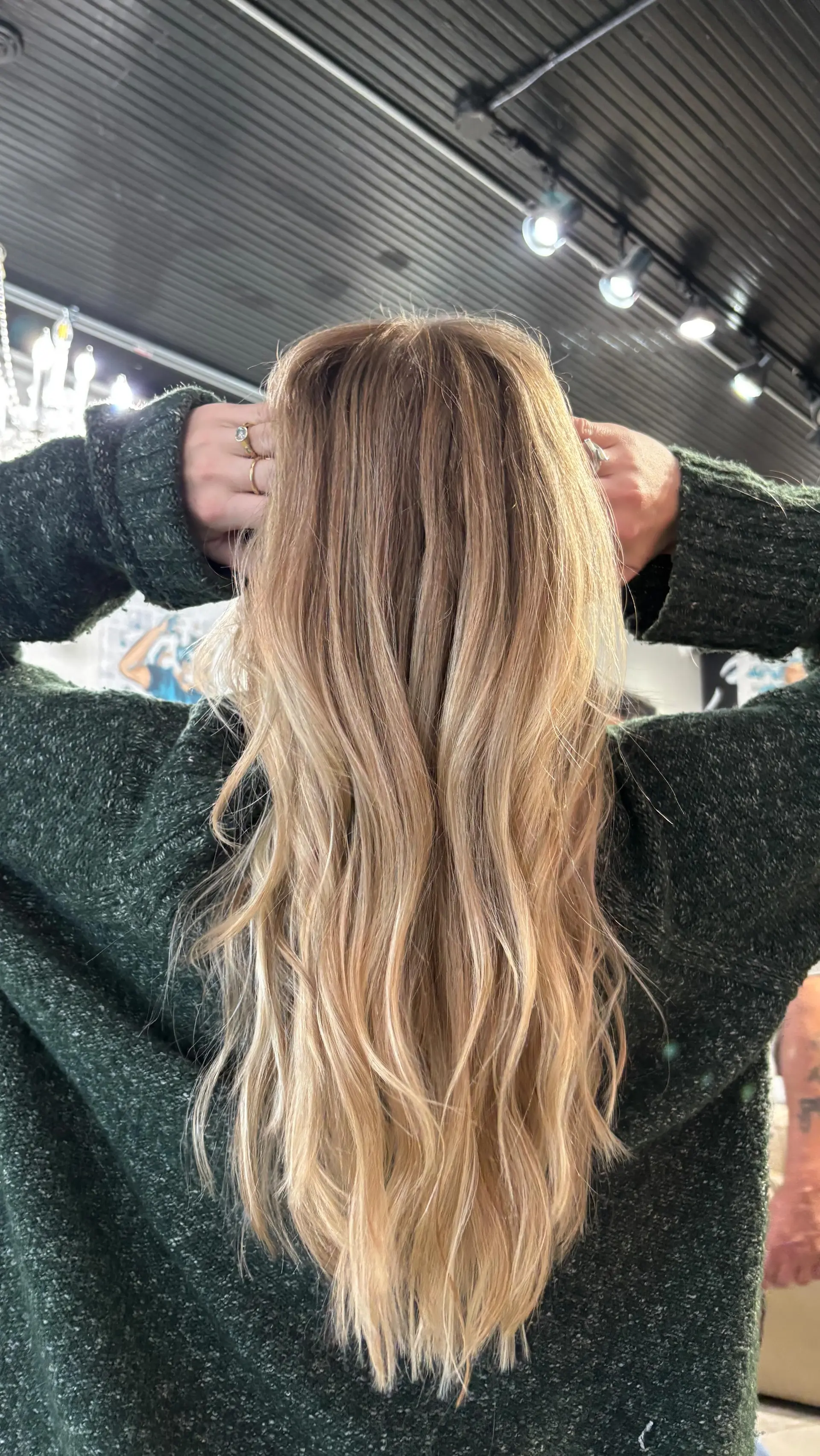 Long hair styled in soft, textured waves featuring seamless warm blonde highlights over a light brown base. 1