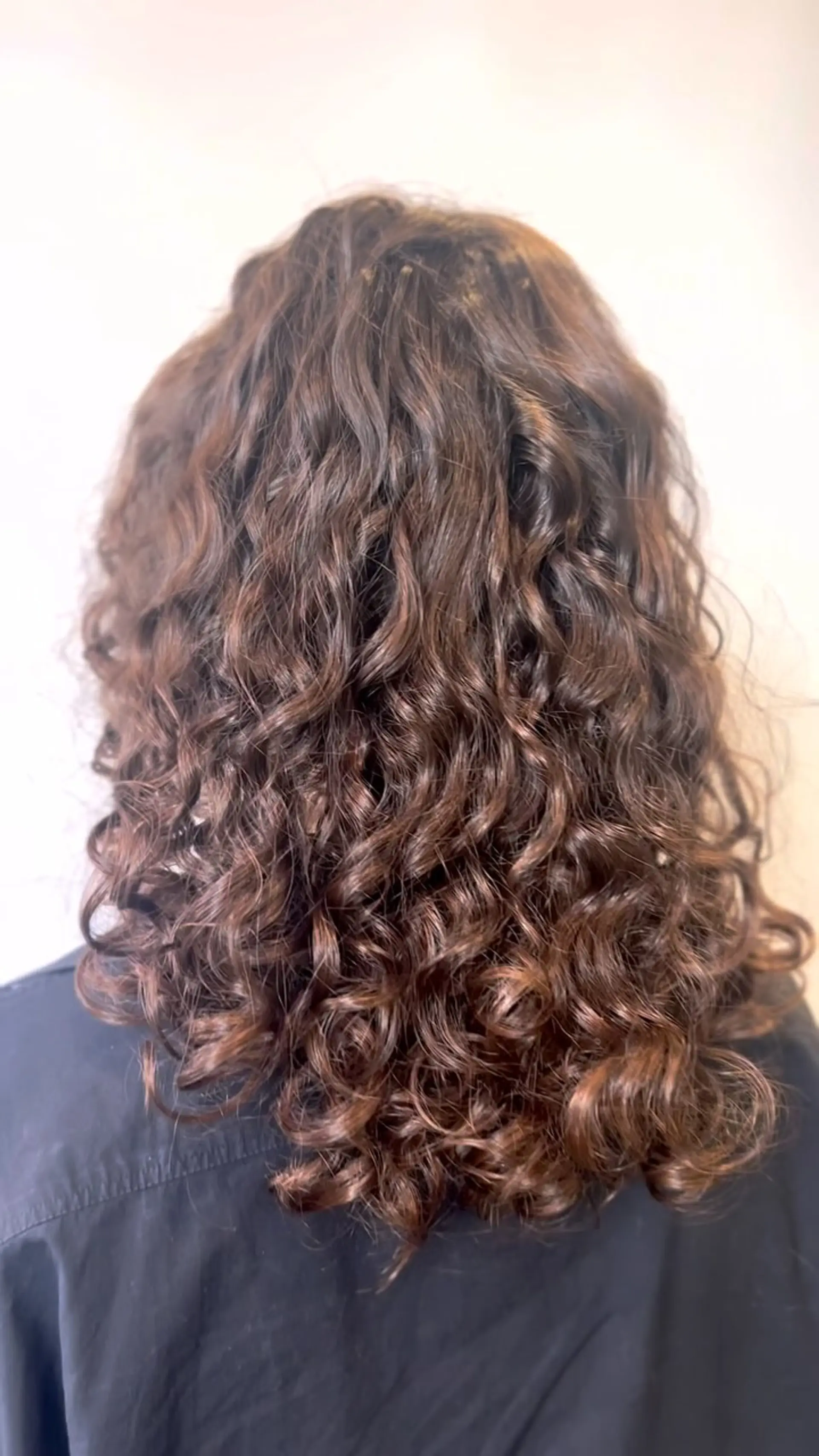 Medium-length layered cut highlighting defined, bouncy natural brunette curls. 1