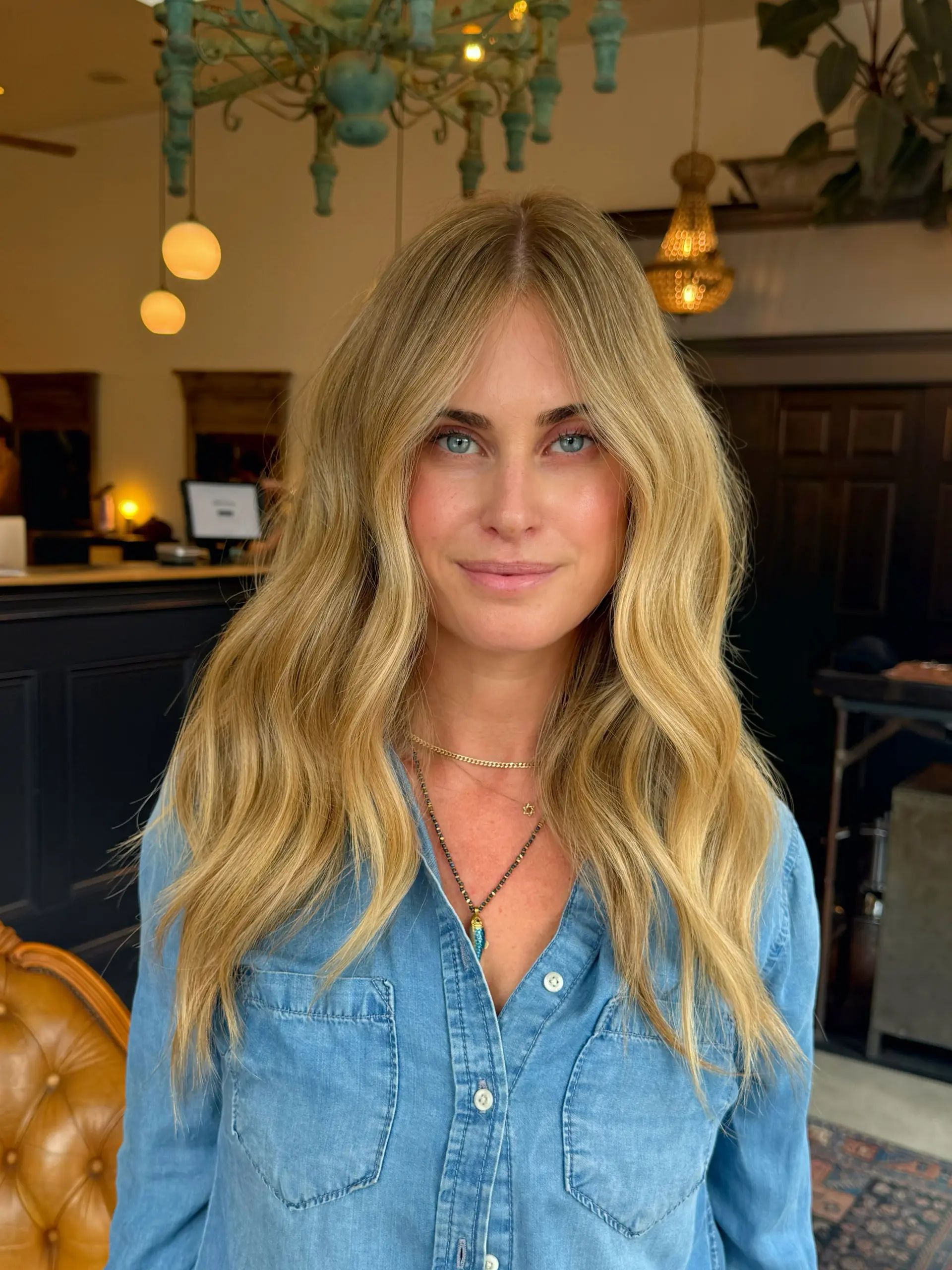 Long warm honey blonde hair styled with soft, natural waves and face-framing layers. 1
