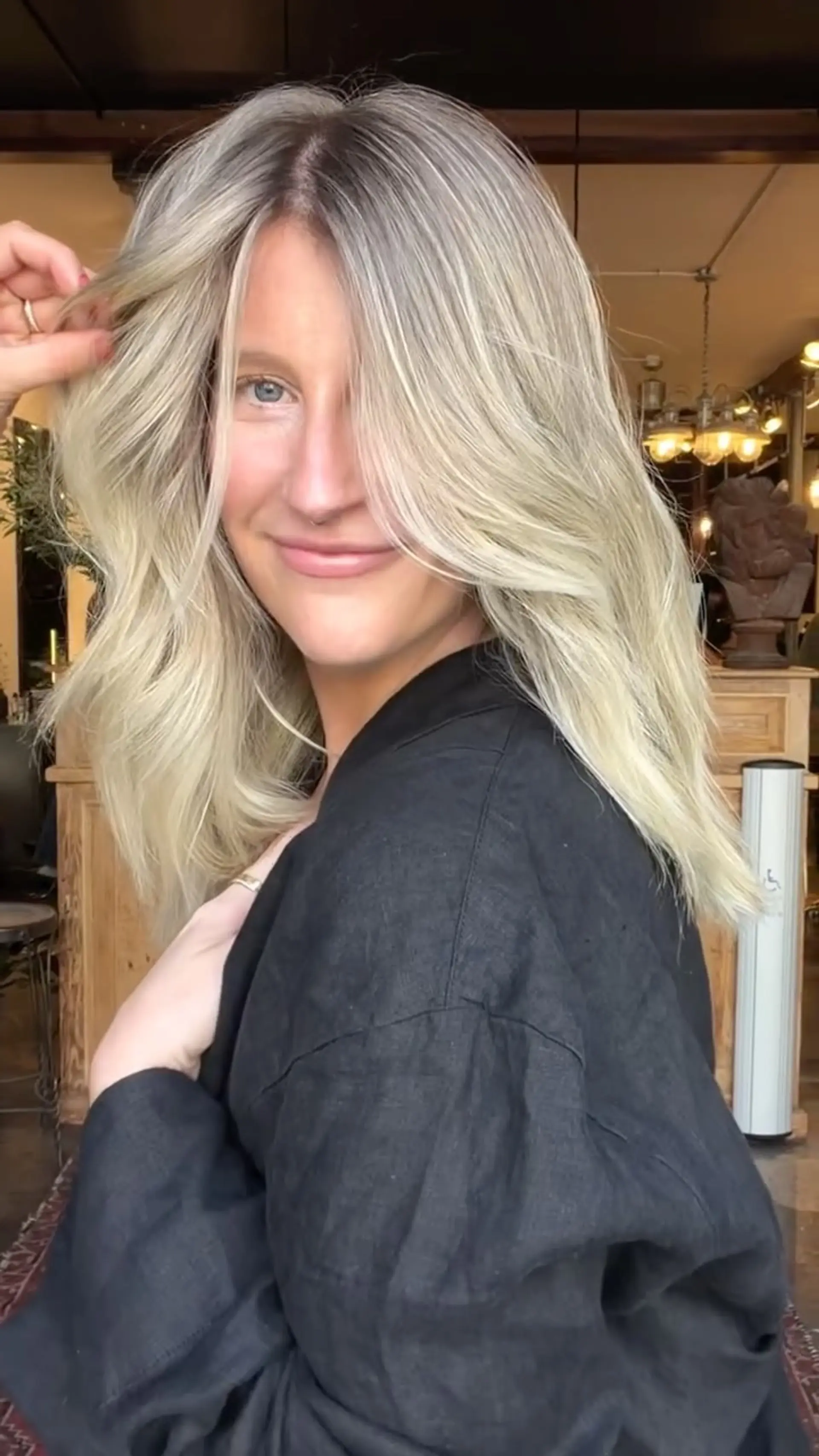 Medium-length pearl blonde hair featuring soft face-framing layers and styled with a voluminous, lived-in blowout. 1