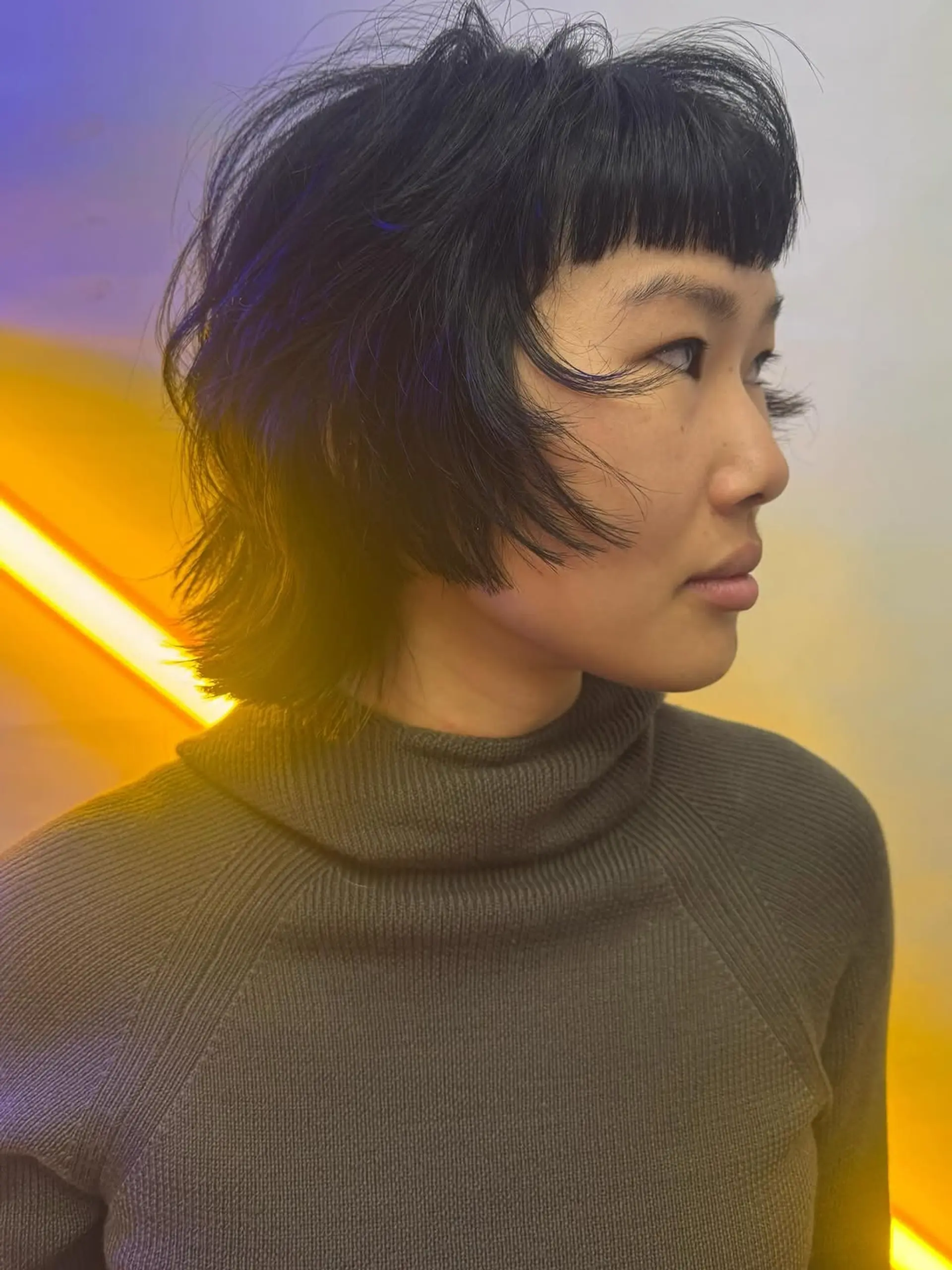 A choppy, shaggy layered cut characterized by textured, piecey movement and bold, straight-across micro bangs. 1