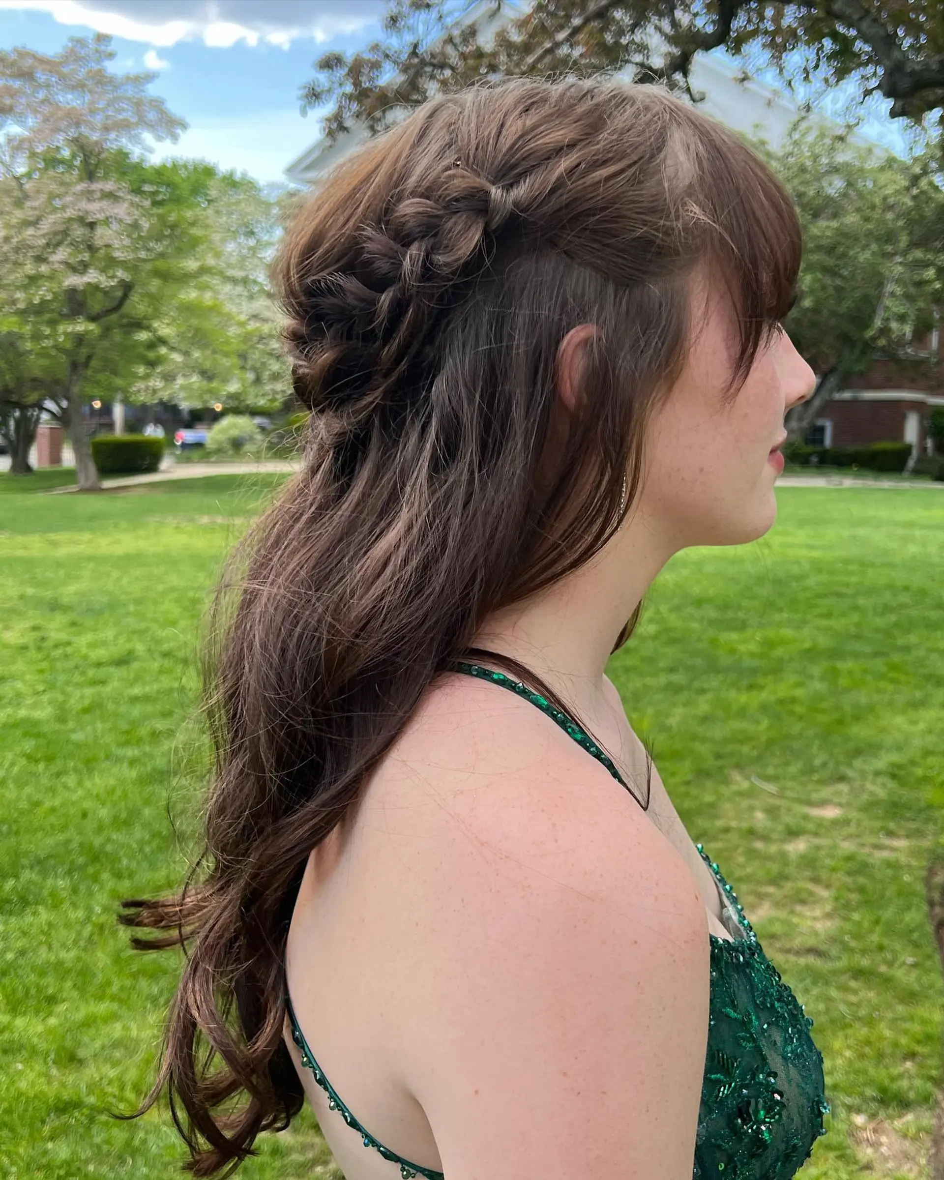 A romantic half-up braided hairstyle with soft loose waves cascading down the back and delicate face-framing fringe. 1