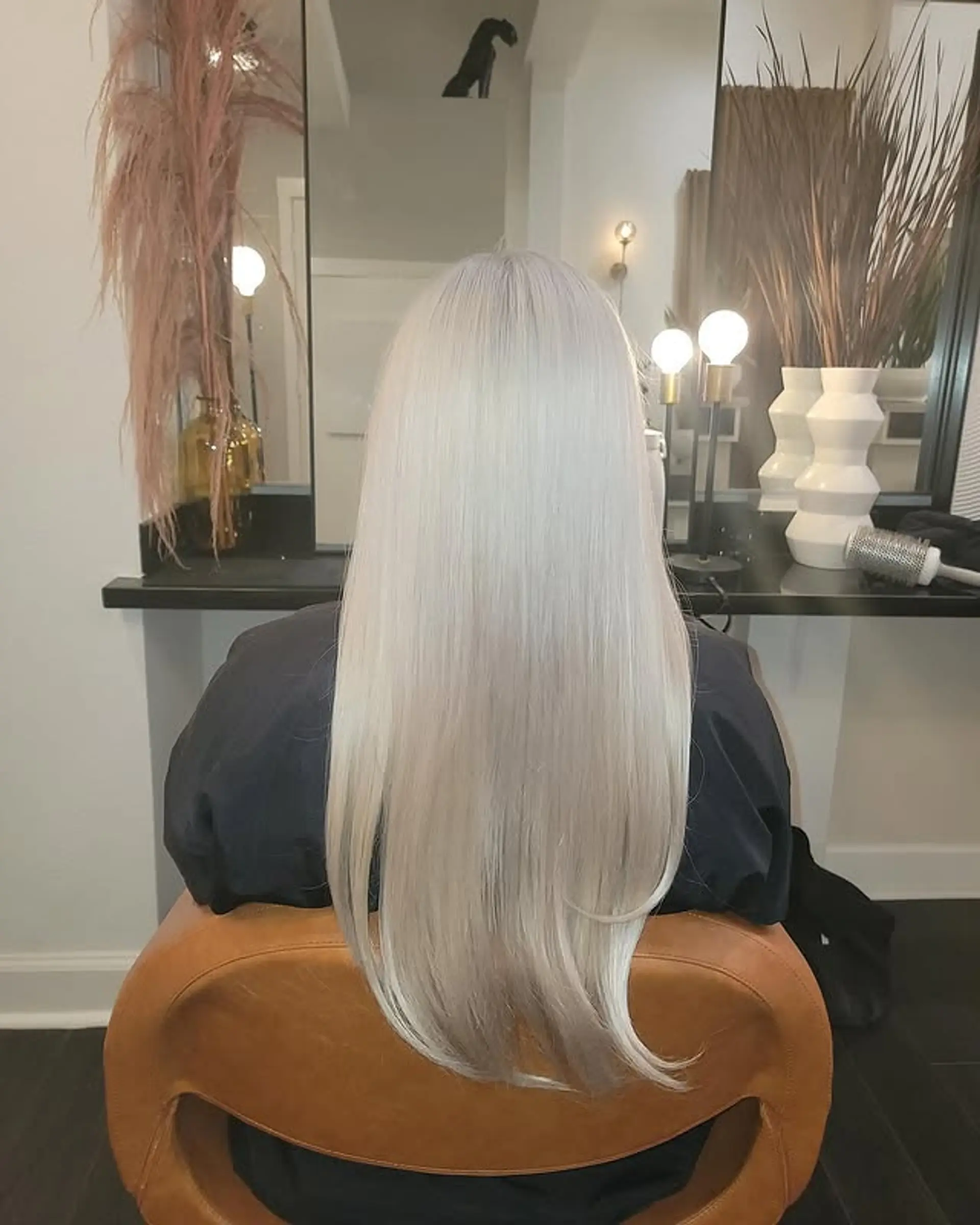 Long, straight platinum icy blonde hair featuring subtle V-cut layers that create a gentle curve and add movement to the ends, giving a sleek and polished finish. 1